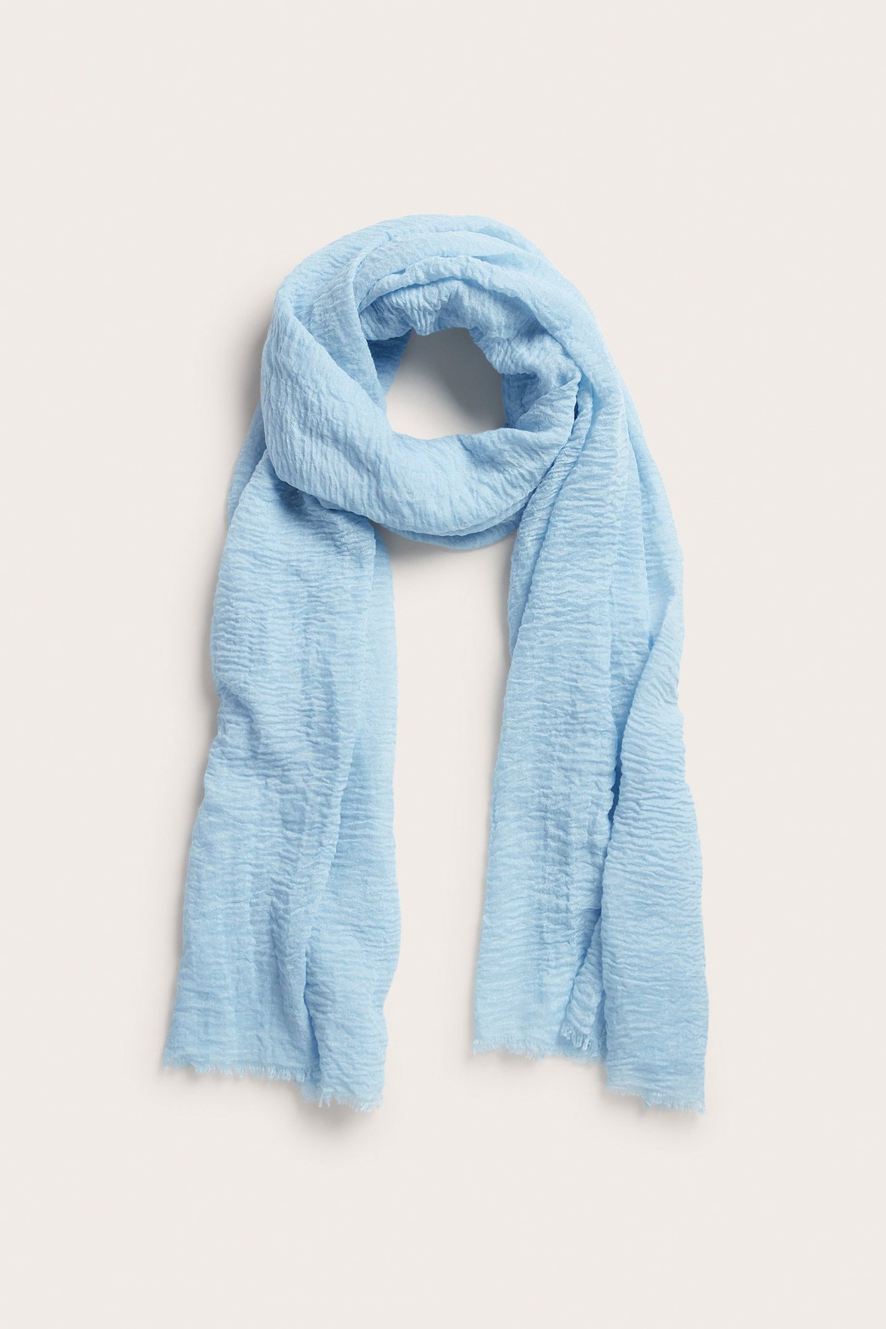 Widok z przodu jasnoniebieskiego marszczonego szalika poliestrowego, udrapowanego.