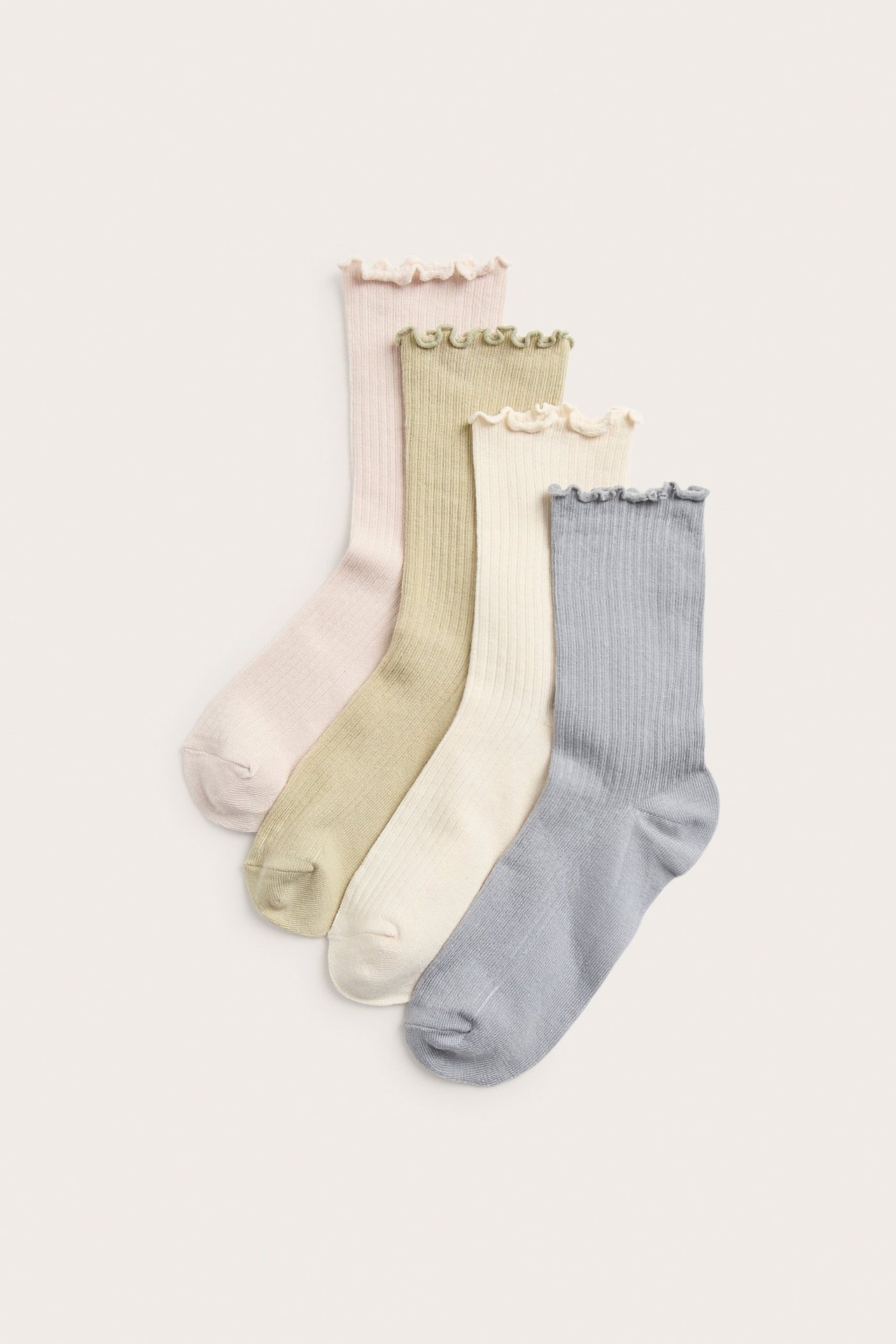 Widok z góry: Cztery prążkowane skarpetki z mieszanki bawełny z falbankami w kolorach beżowym, zielonym, kremowym i niebieskim.