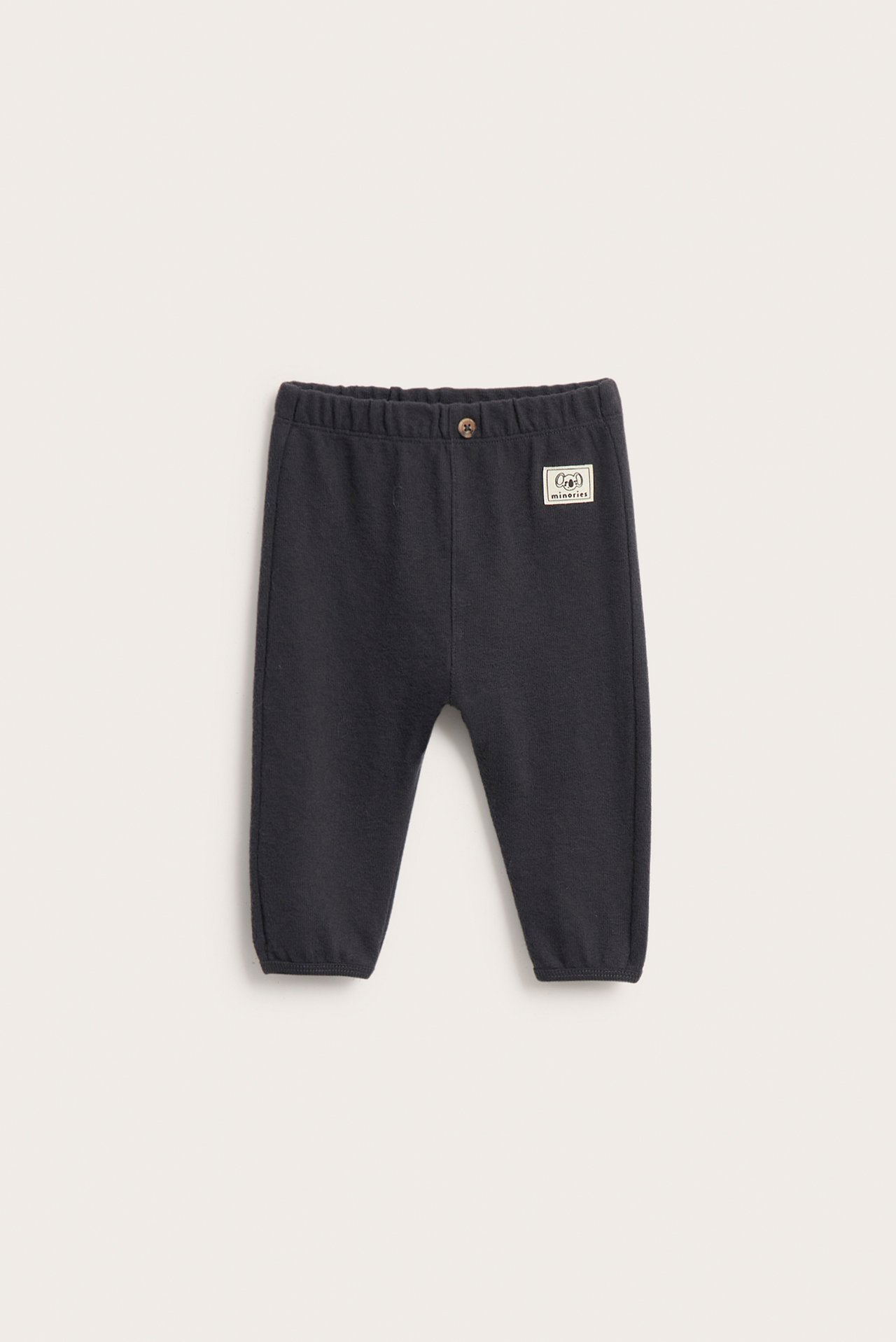 Edestäpäin: Mustat vauvan collegehousut joustovyötäröllä, valenapilla ja resoreilla lahkeissa.