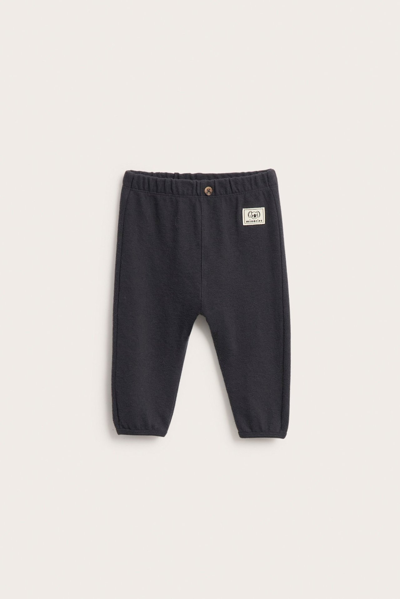 Edestäpäin: Mustat vauvan collegehousut joustovyötäröllä, valenapilla ja resoreilla lahkeissa.