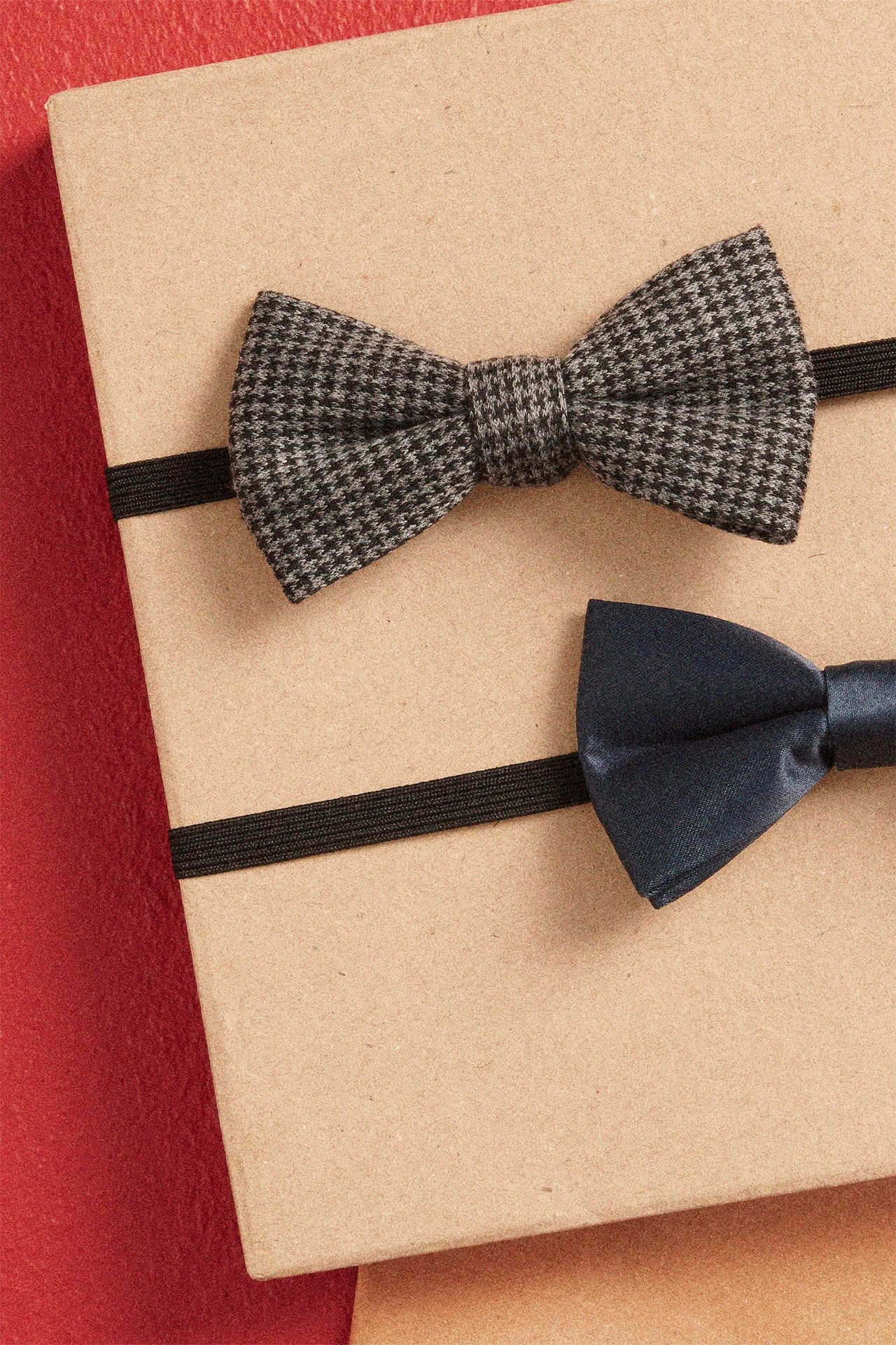 Närbild av en grå hundtandsmönstrad fluga och en mörkblå satin-fluga.