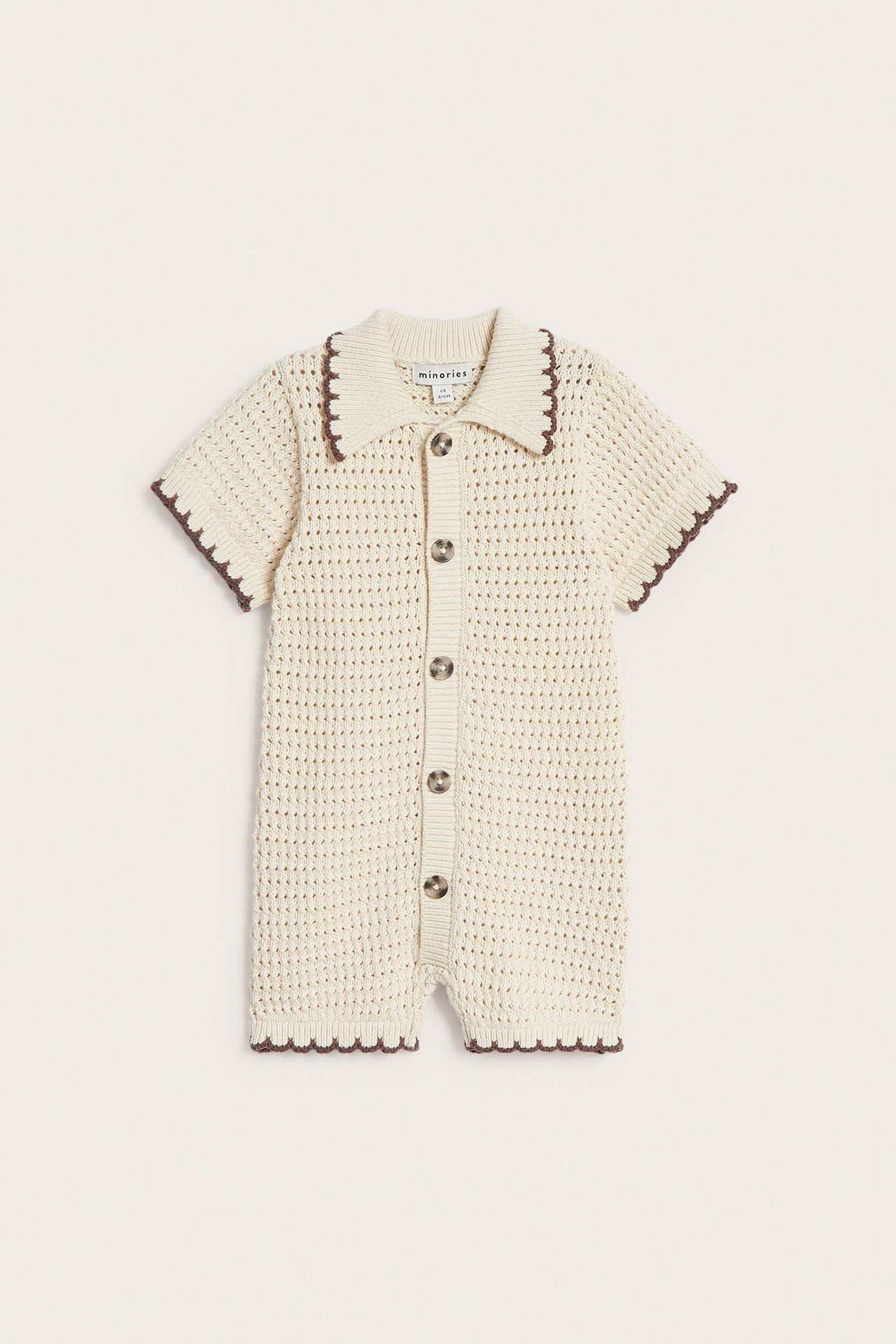Frontvisning av en beige strikket babybody med bølget krage, korte ermer og knapper foran.