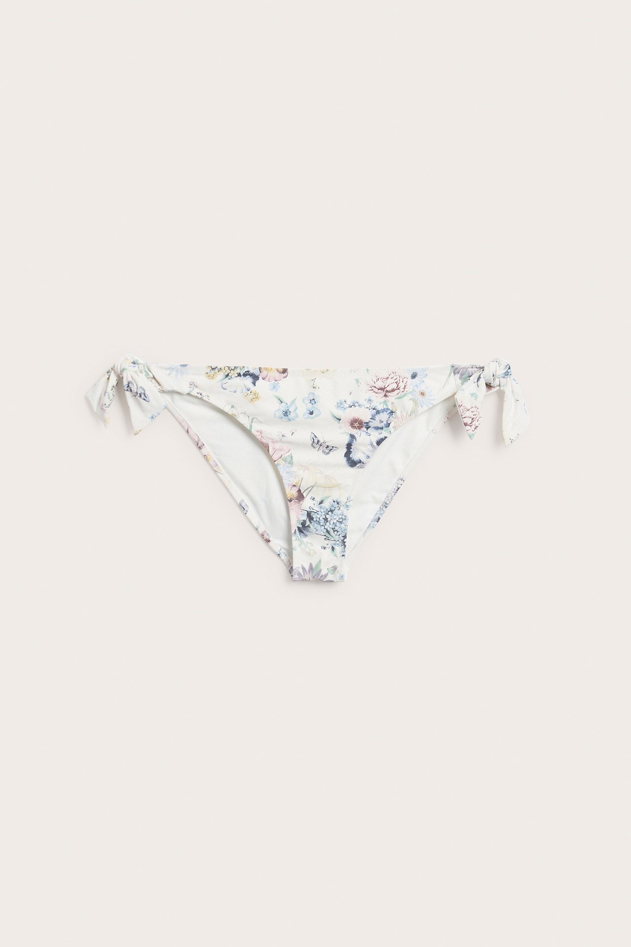Framifrån, offwhite blommig brazilian bikinitrosa med knytband i sidorna.