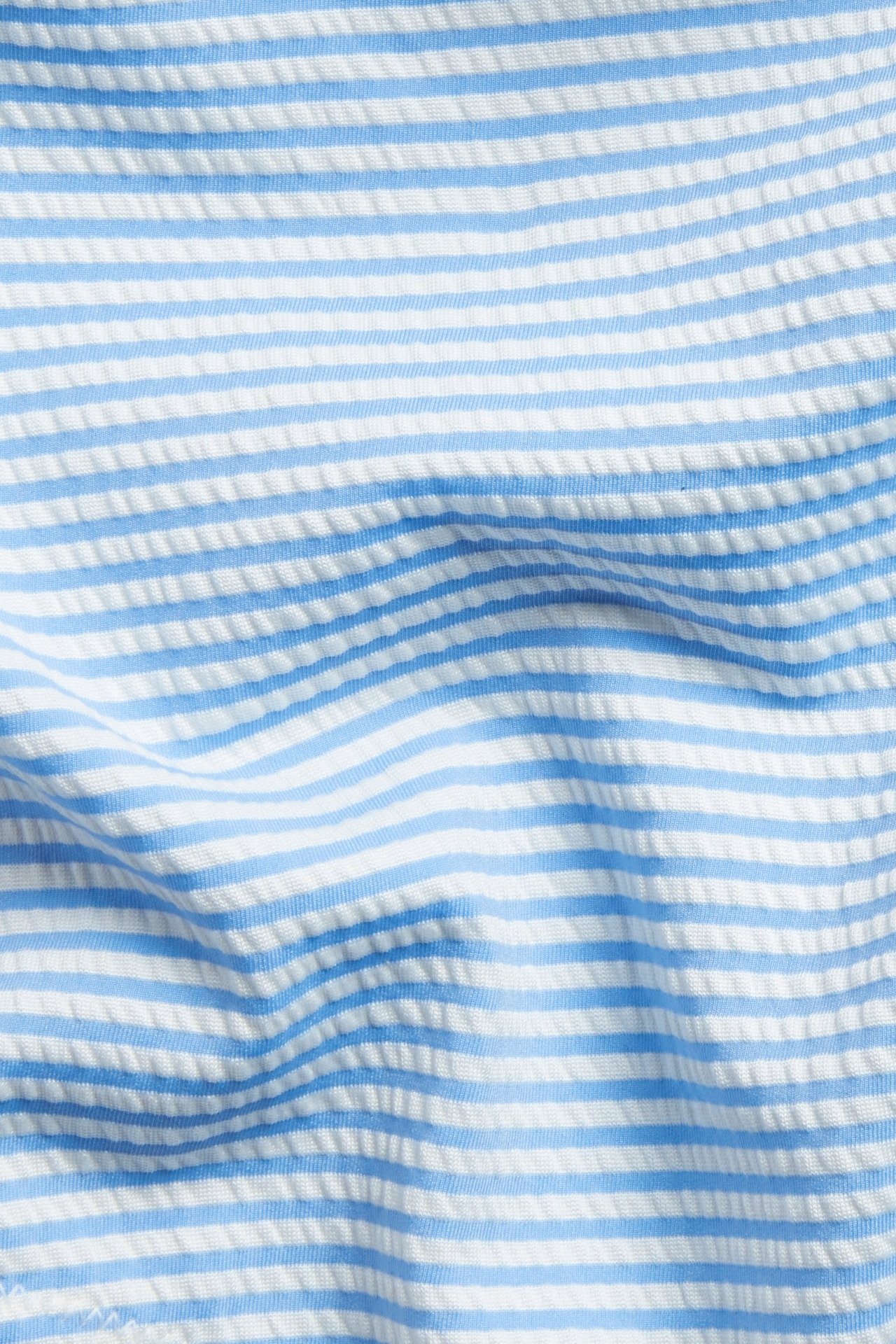 Lähikuva vaaleansinisestä ja valkoisesta raidallisesta, tekstuuripintaisesta bikinialaosakankaasta.