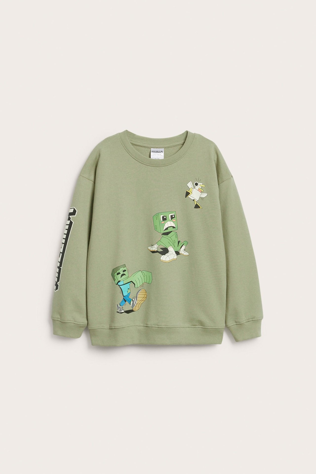 Edestä näkymä lasten salvianvihreästä puuvillapaidasta ribbireunoilla ja Minecraft-painatuksella.