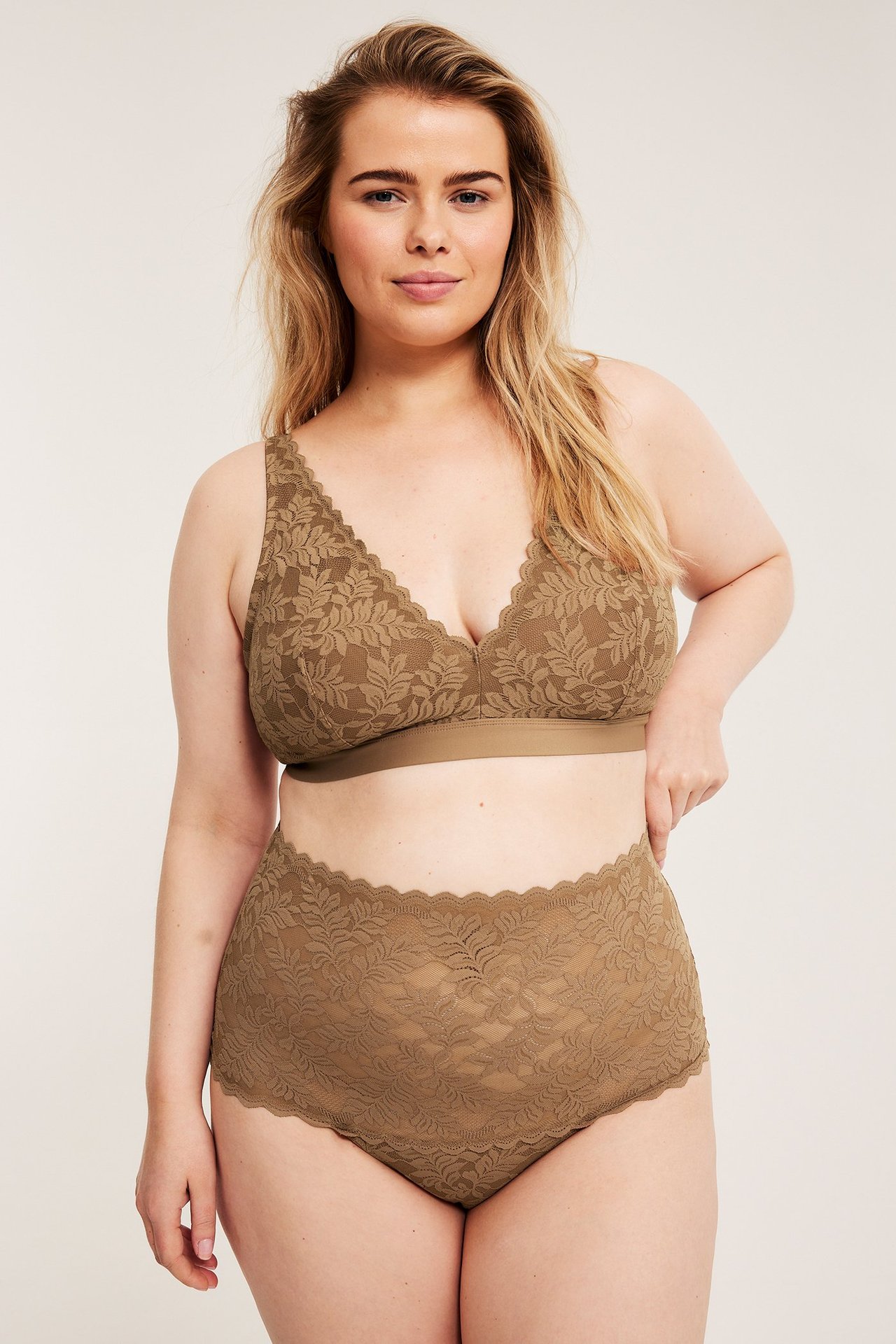 Widok z przodu: kobieta w brązowych koronkowych figach z wysokim stanem i pasującym biustonoszu.