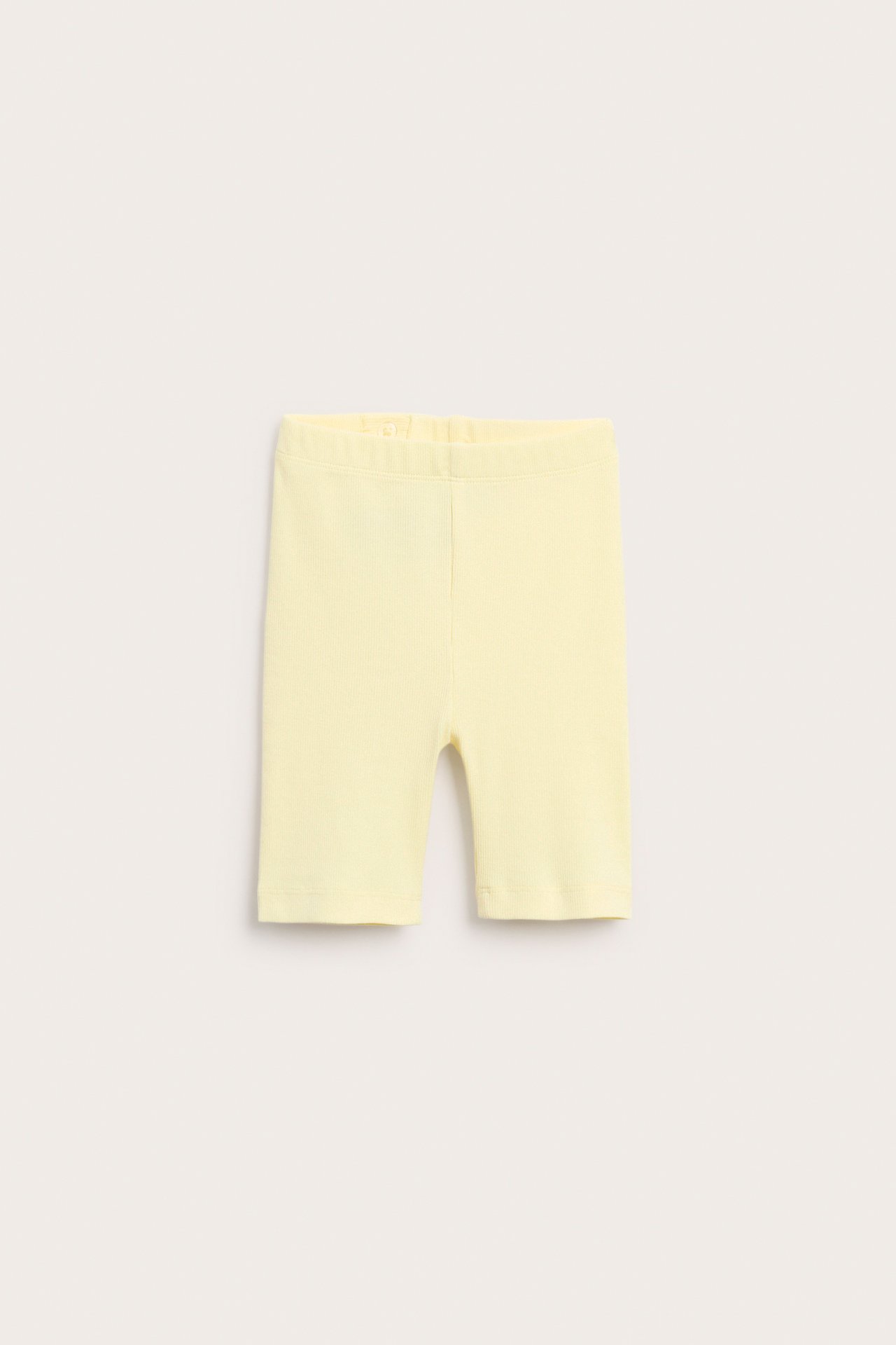 Framifrån, ljusgula ribbade cykelbyxor för barn med resår i midjan.