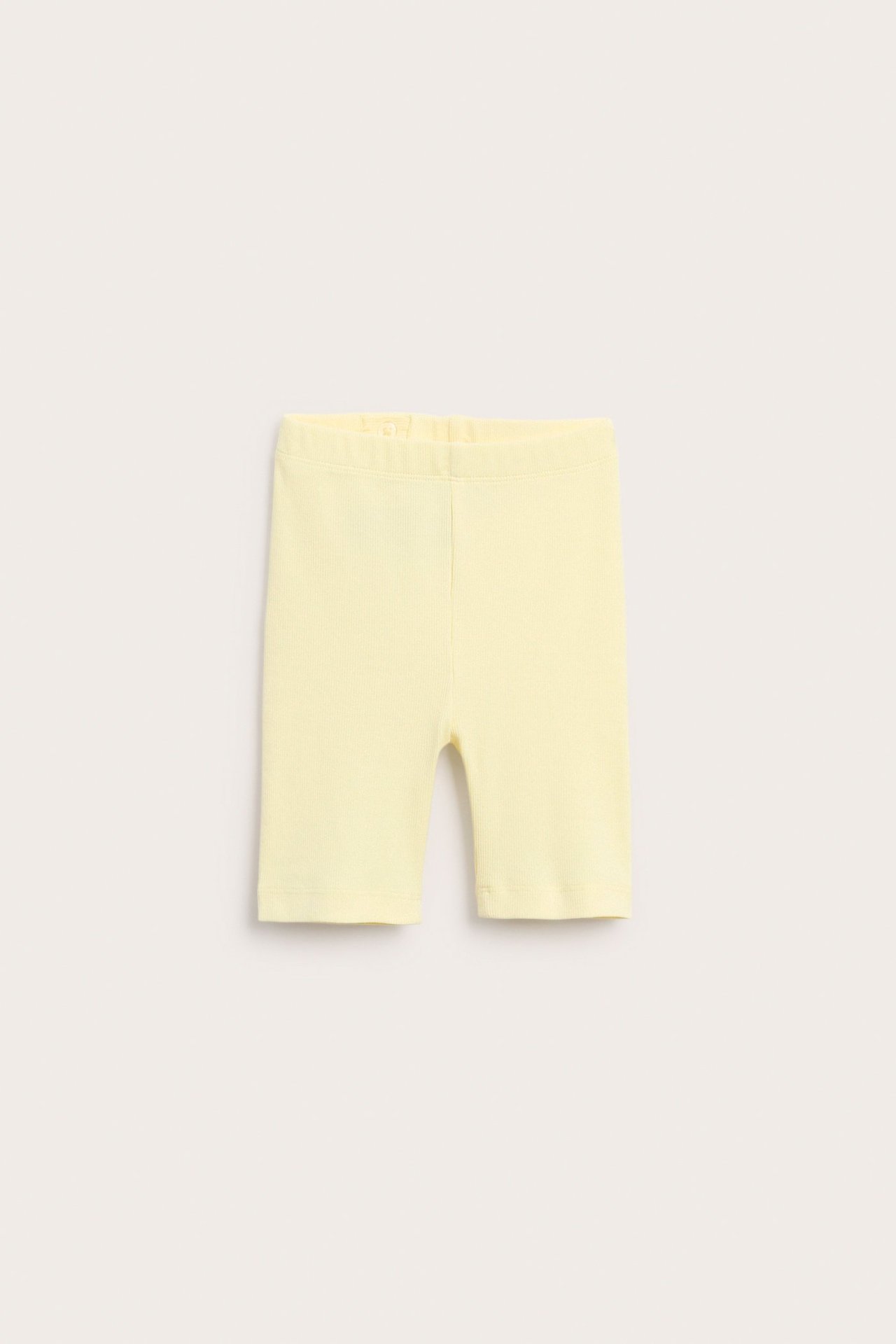 Edestä, vaaleankeltaiset lasten ribbipyöräilyshortsit joustavalla vyötäröllä.