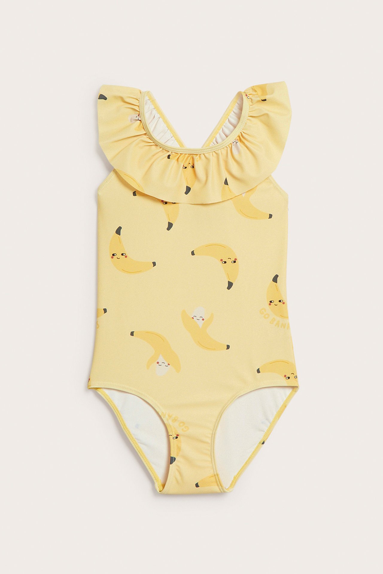 Edestäpäin: Keltainen lasten uimapuku kierrätyspolyesteristä banaanikuviolla ja röyhelökauluksella.