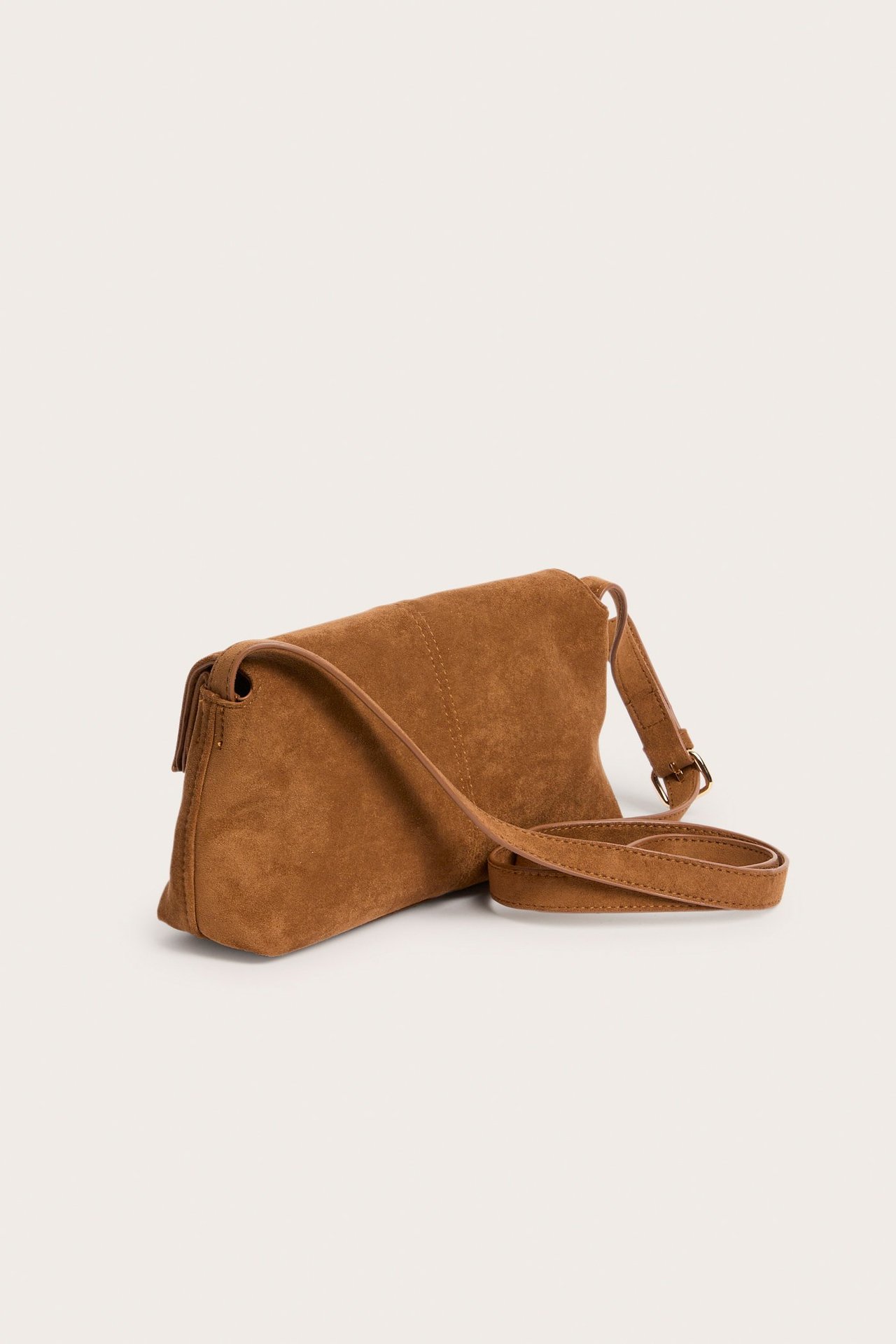 Sivukuva ruskeasta mokkajäljitelmä olkalaukusta, jossa on läppä ja säädettävä hihna.