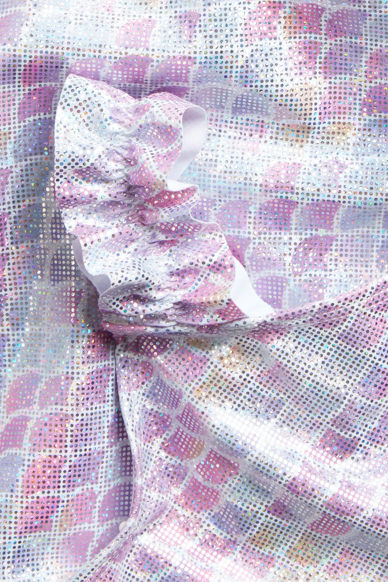 Zbliżenie jasnofioletowego, błyszczącego stroju kąpielowego z wzorem syreny i marszczonym ramiączkiem.