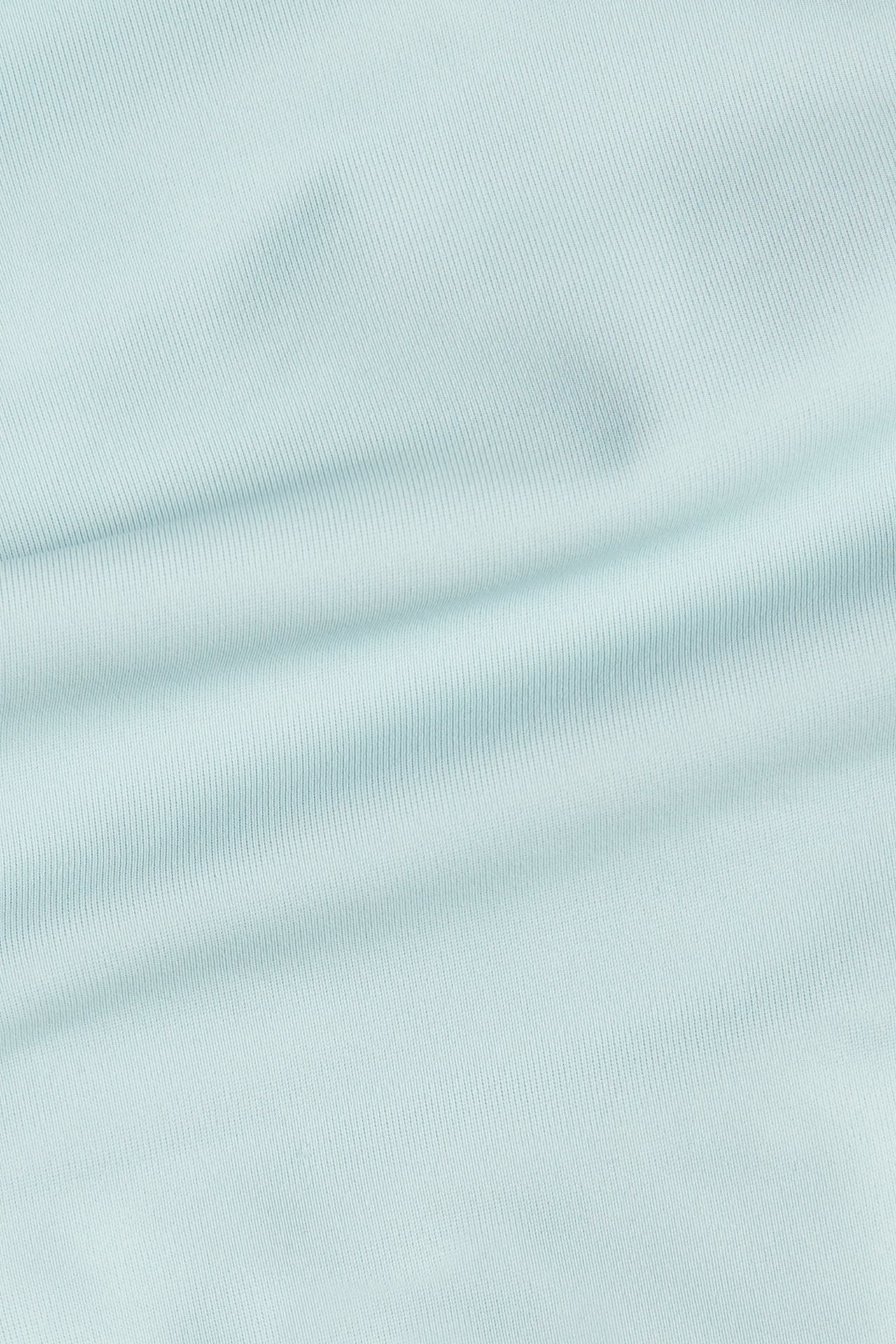 Närbild av ett ljust turkost ribbat enfärgat tyg.