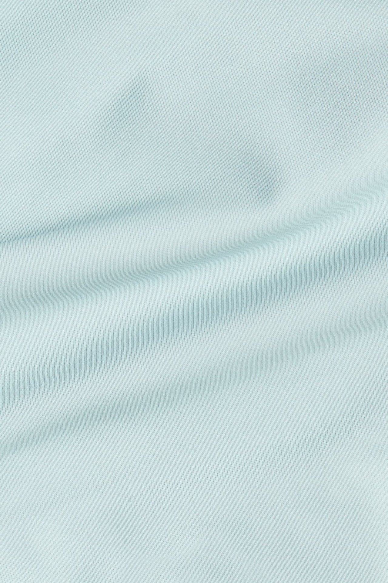 Närbild av ett ljust turkost ribbat enfärgat tyg.