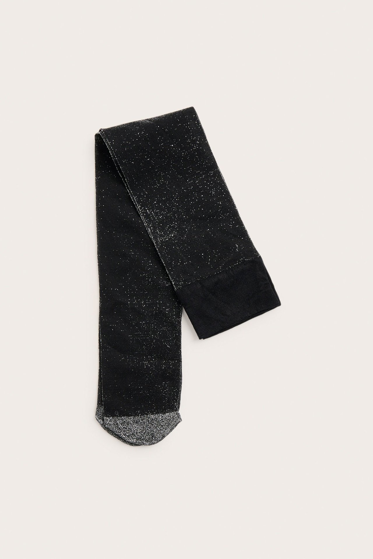Ovanifrån vy av vikta svarta glittriga lurex knästrumpor.