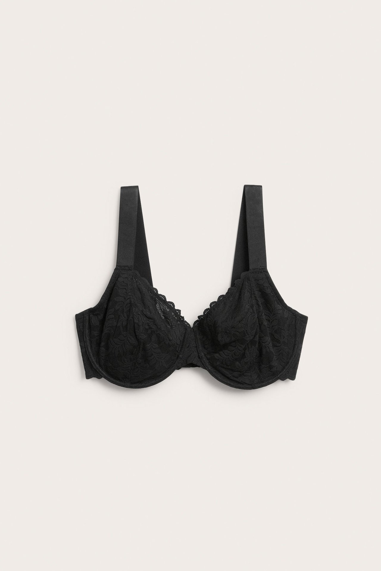 Edestä kuvattu musta kaarituellinen minimizer-rintaliivi pehmeää pitsiä leveillä olkaimilla.