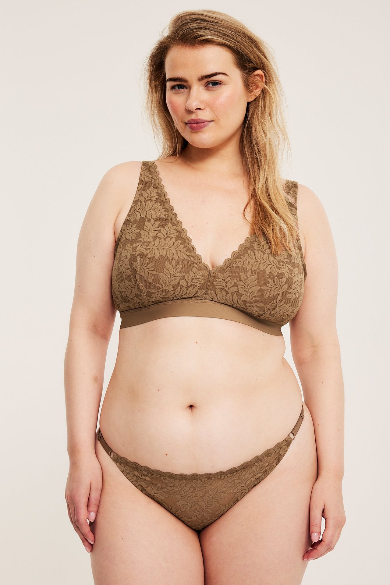 Frontbilde av kvinne i brun blondebralette med bladmønster og matchende truser.