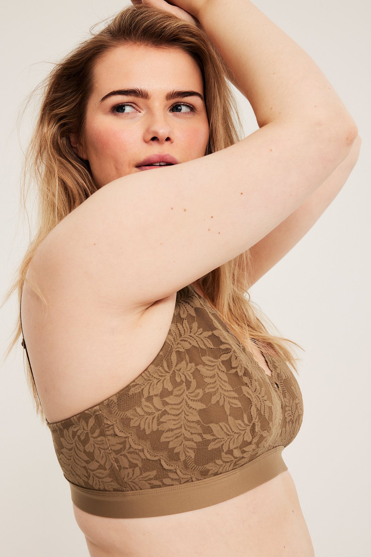 Nærbilde: kvinne i brun blonde-bralette med bladverk og elastisk bånd.