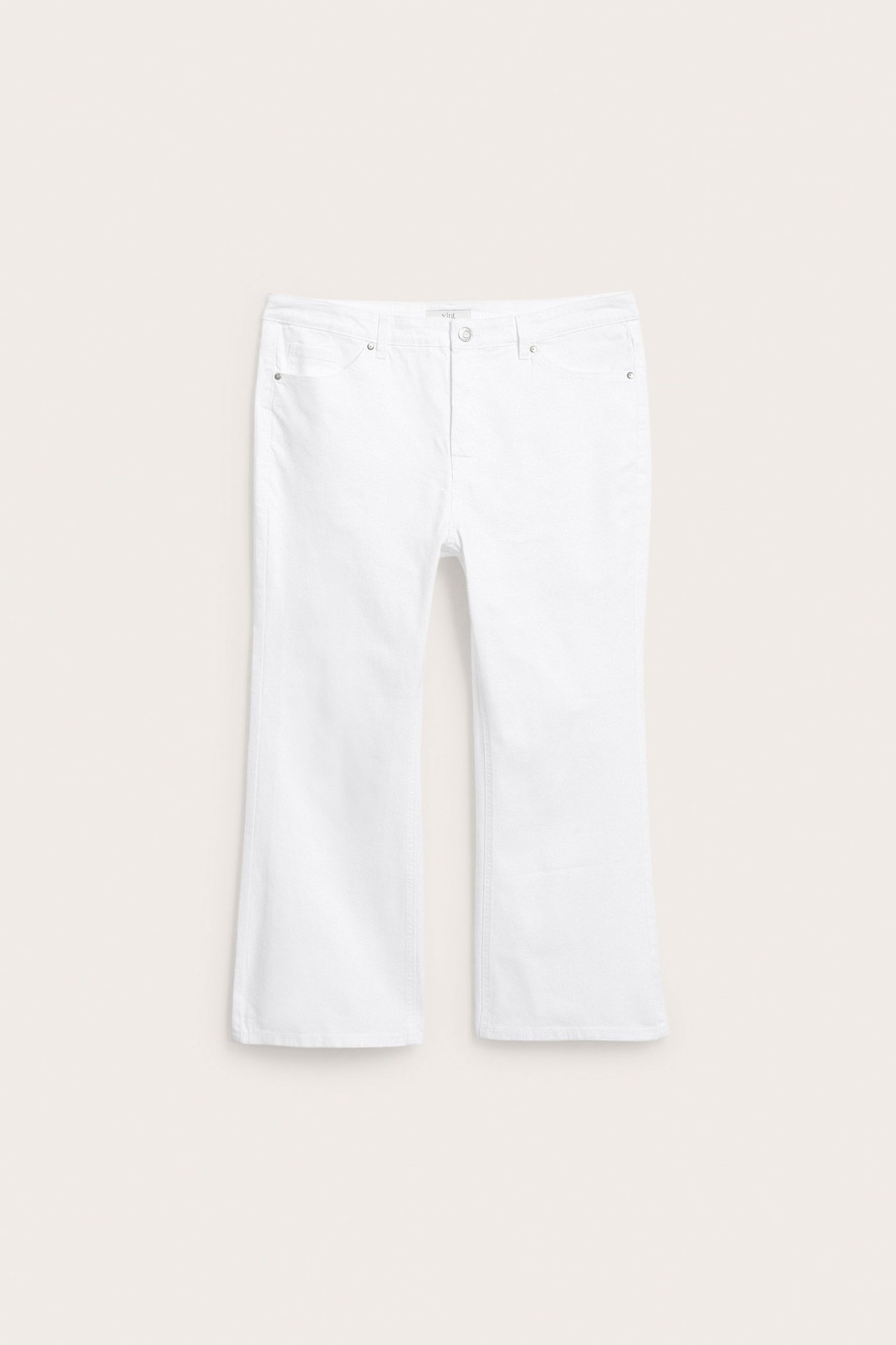 Edestä näkymä valkoisista korkeavyötäröisistä vajaamittaisista flare-farkuista.