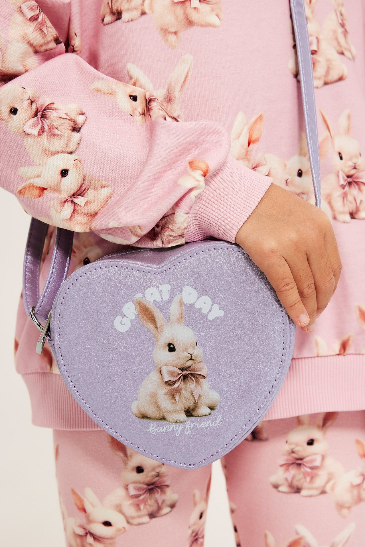 Fioletowa serca torba z wzorem zajączka, na dziecku w kolorowym stroju.