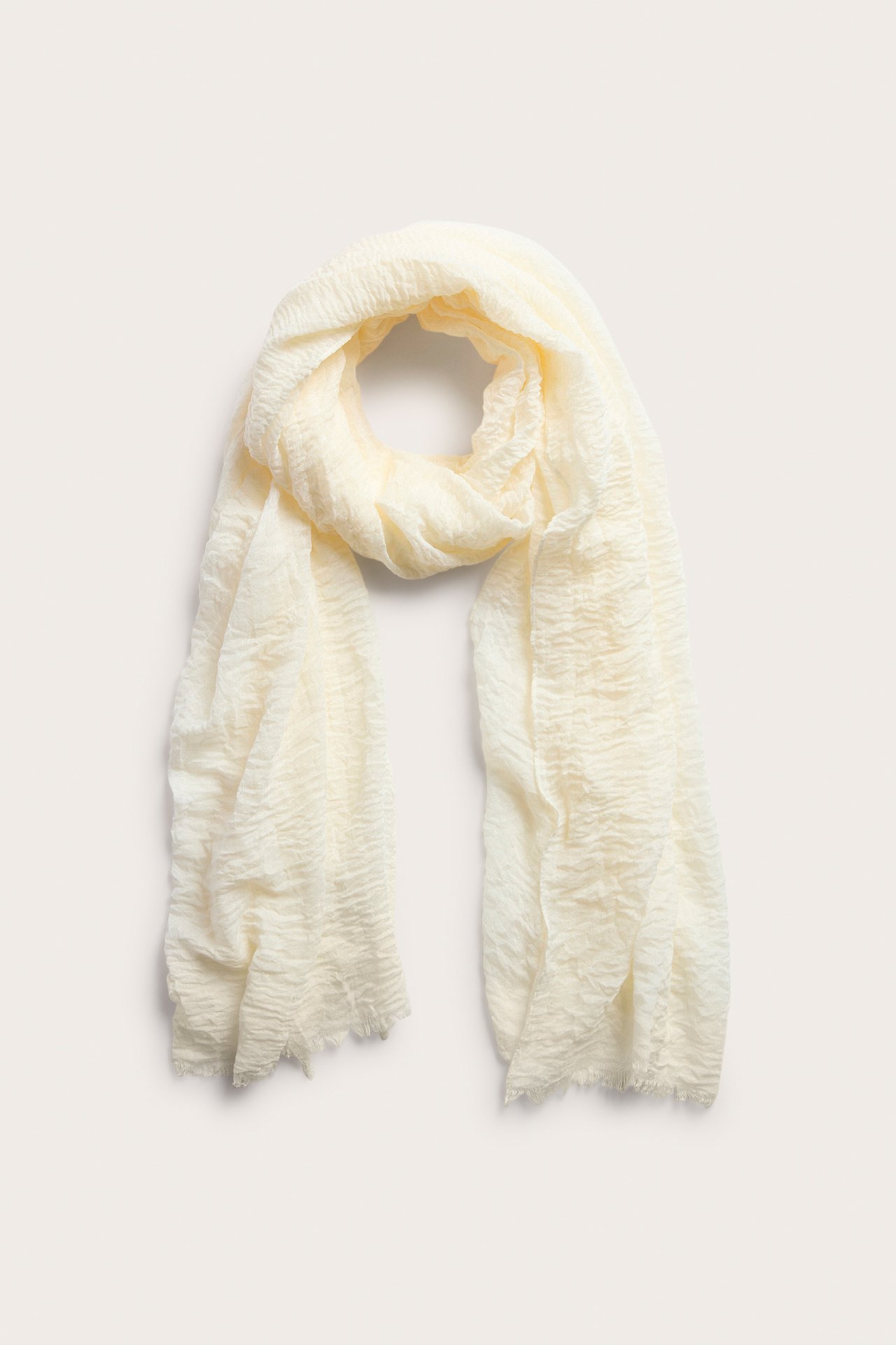 Ylhäältä: Luonnonvalkoinen ryppyinen polyesterihuivi, jossa on raakareunat, kauniisti aseteltuna.