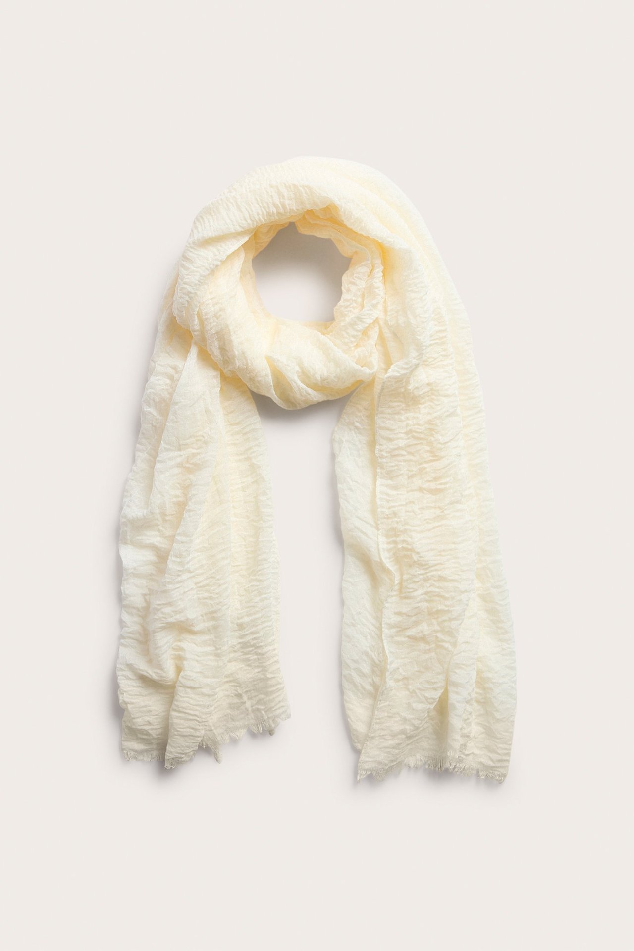 Ylhäältä: Luonnonvalkoinen ryppyinen polyesterihuivi, jossa on raakareunat, kauniisti aseteltuna.