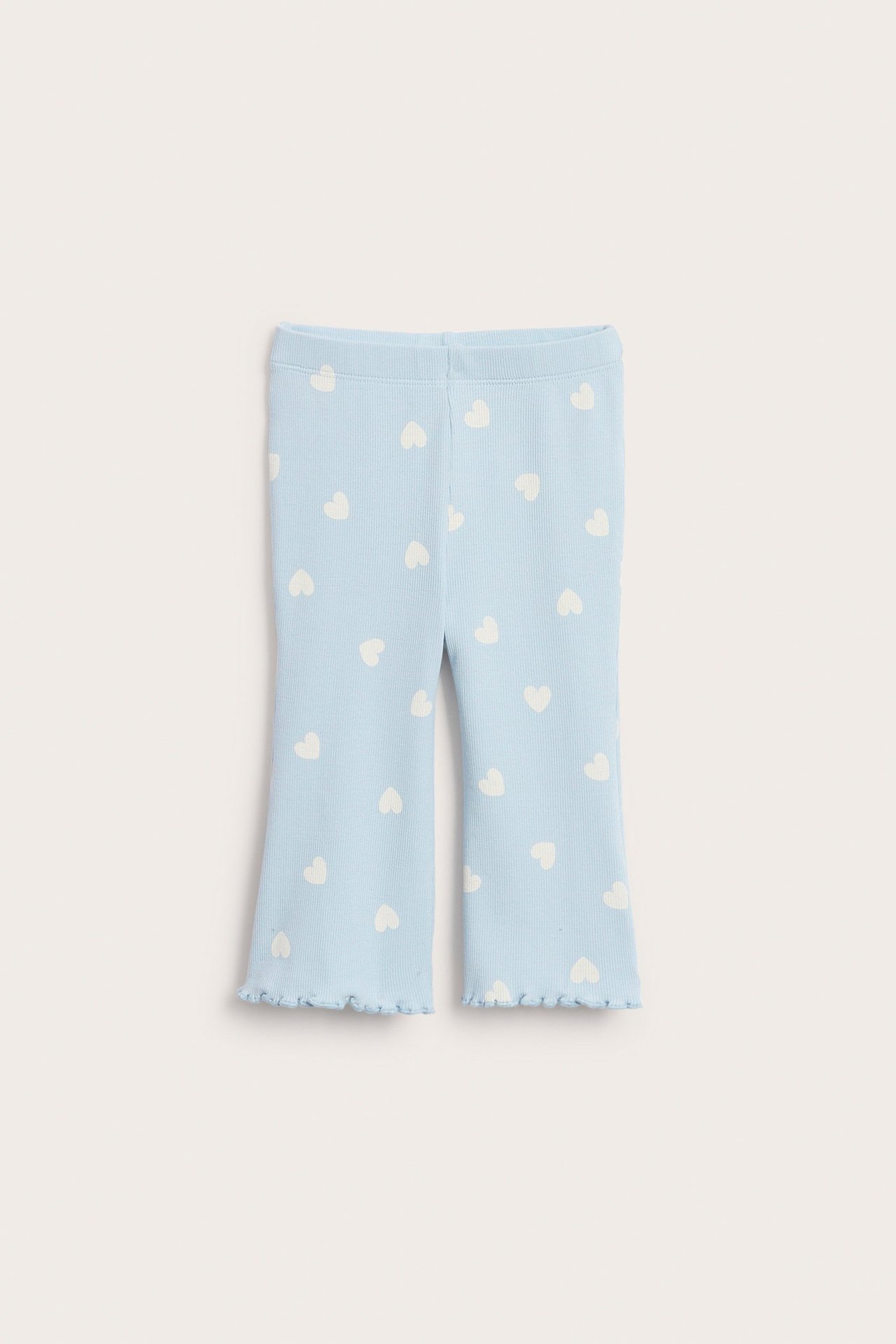 Vauvan vaaleansiniset uurretut trumpettileggingsit valkoisella sydänkuviolla ja aaltoilevilla reunoilla, edestä.