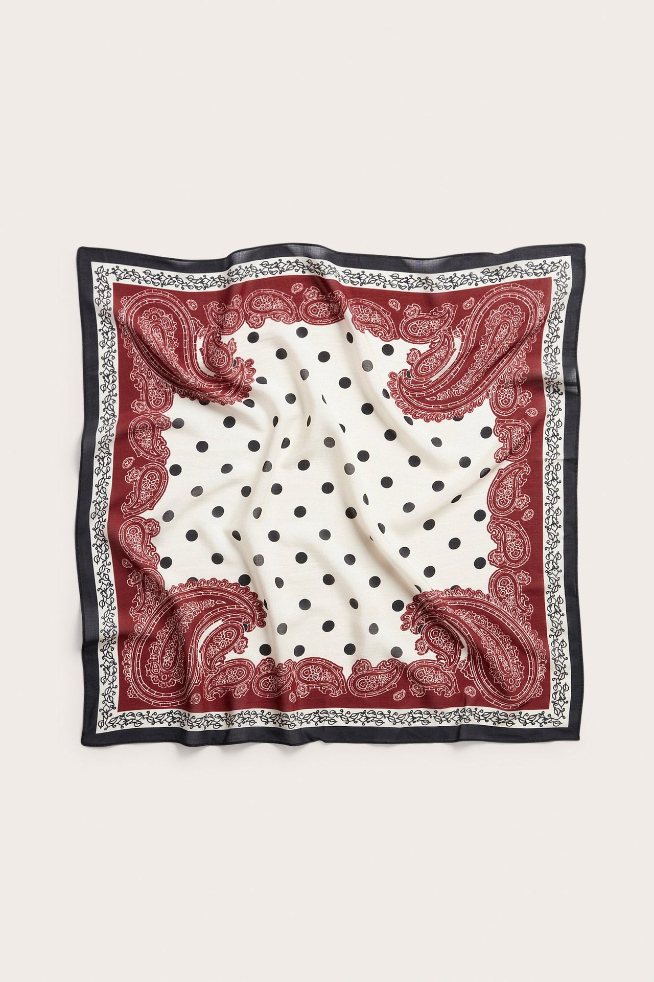 Ylhäältä: Neliönmuotoinen vaalea beige huivi, jossa mustia pilkkuja ja tummanpunainen paisley-reuna.