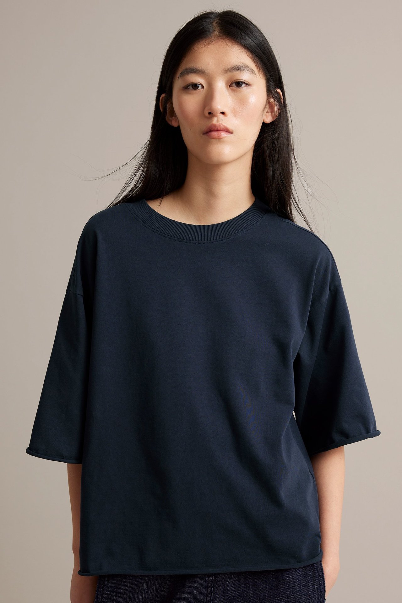 Nainen päällä tummansininen paksu trikoot-paita, suora etunäkymä.