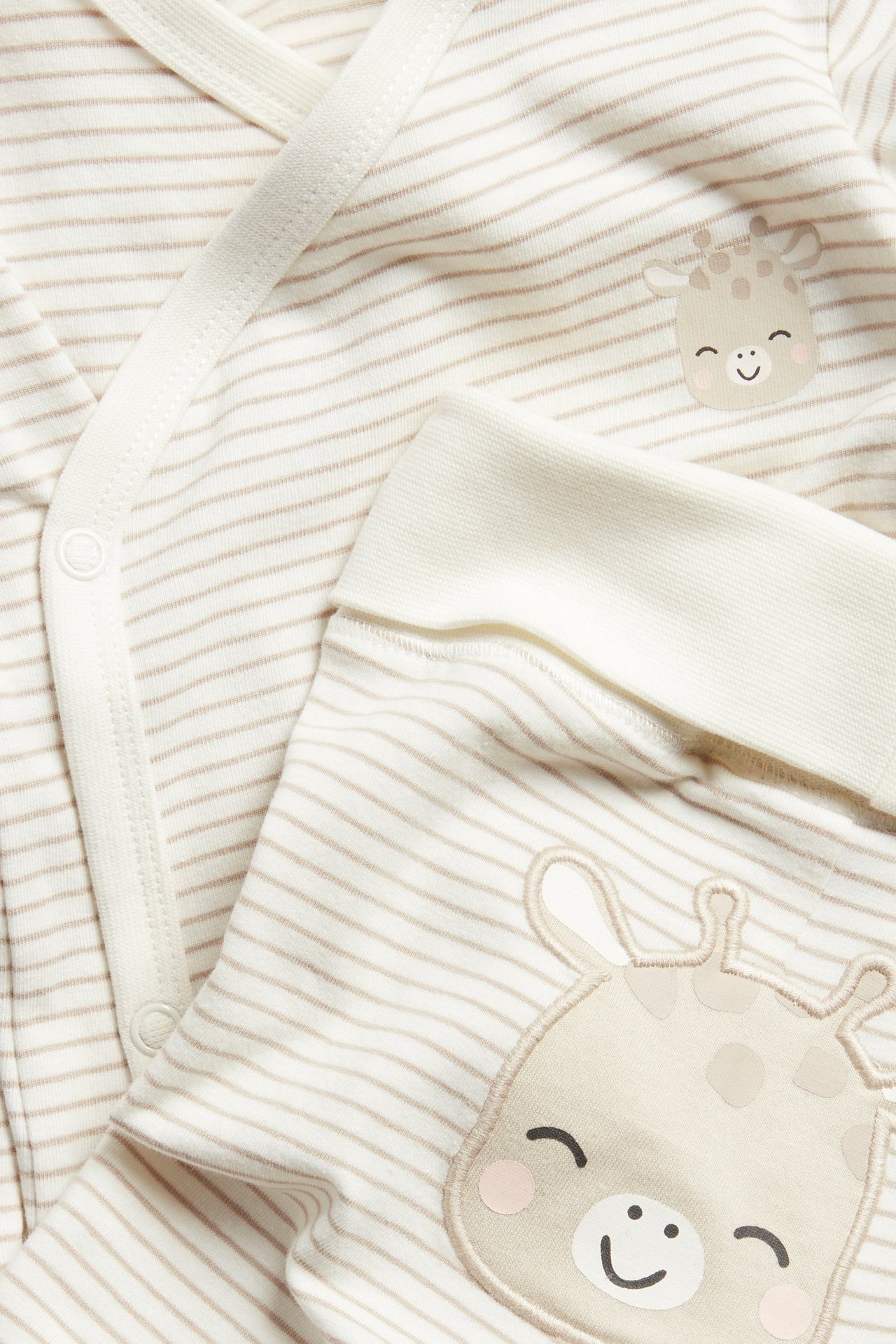 Nærbilde: Stripet beige babybody med sjiraffapplikasjon og matchende stripete leggings.