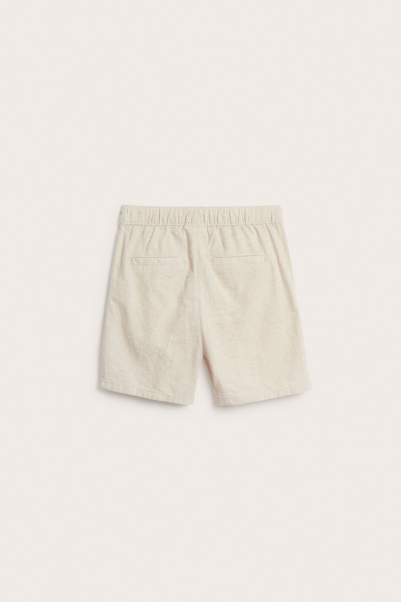 Vaaleat beiget pellavasekoiteshortsit takaa, joissa joustava vyötärö ja valeperehtaskut.