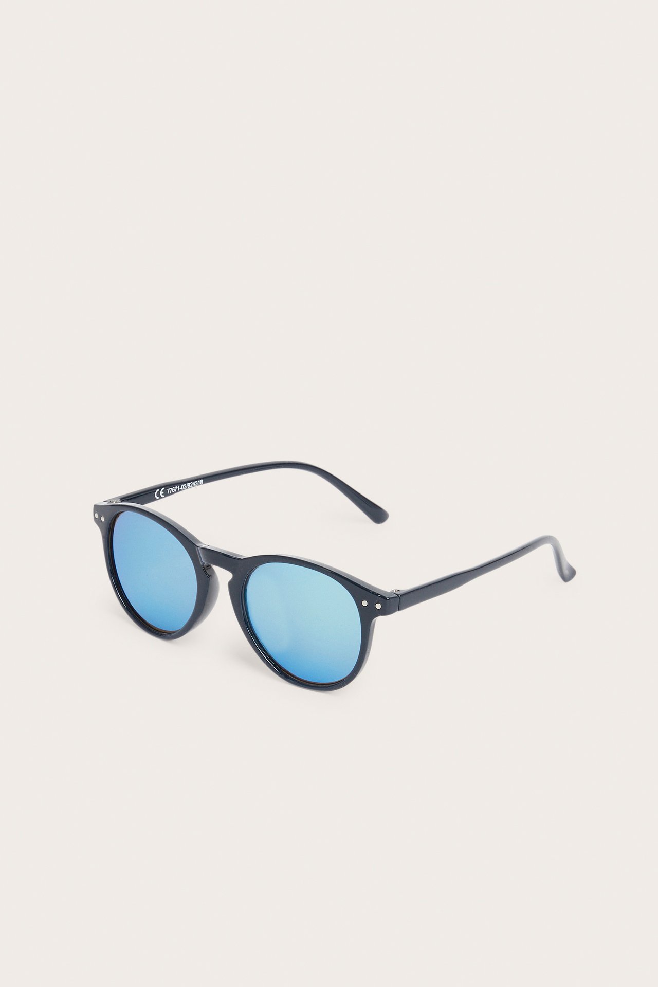 Skośny widok: ciemnoniebieskie, okrągłe okulary przeciwsłoneczne z lustrzanymi soczewkami.