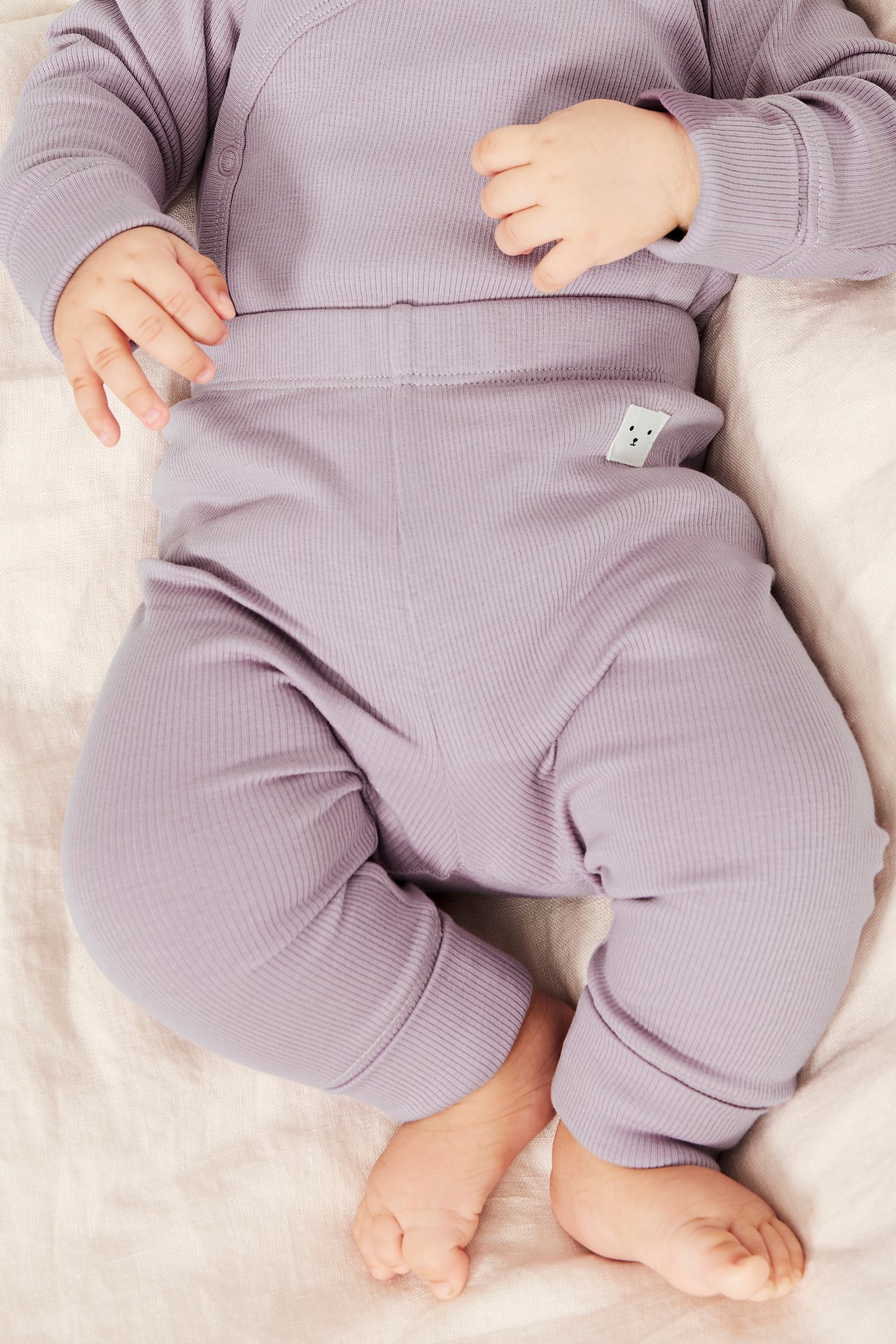 Ylhäältä: vauva liiloissa ribbileggingseissä leveillä resoreilla ja yhteensopivassa ribbipaidassa.