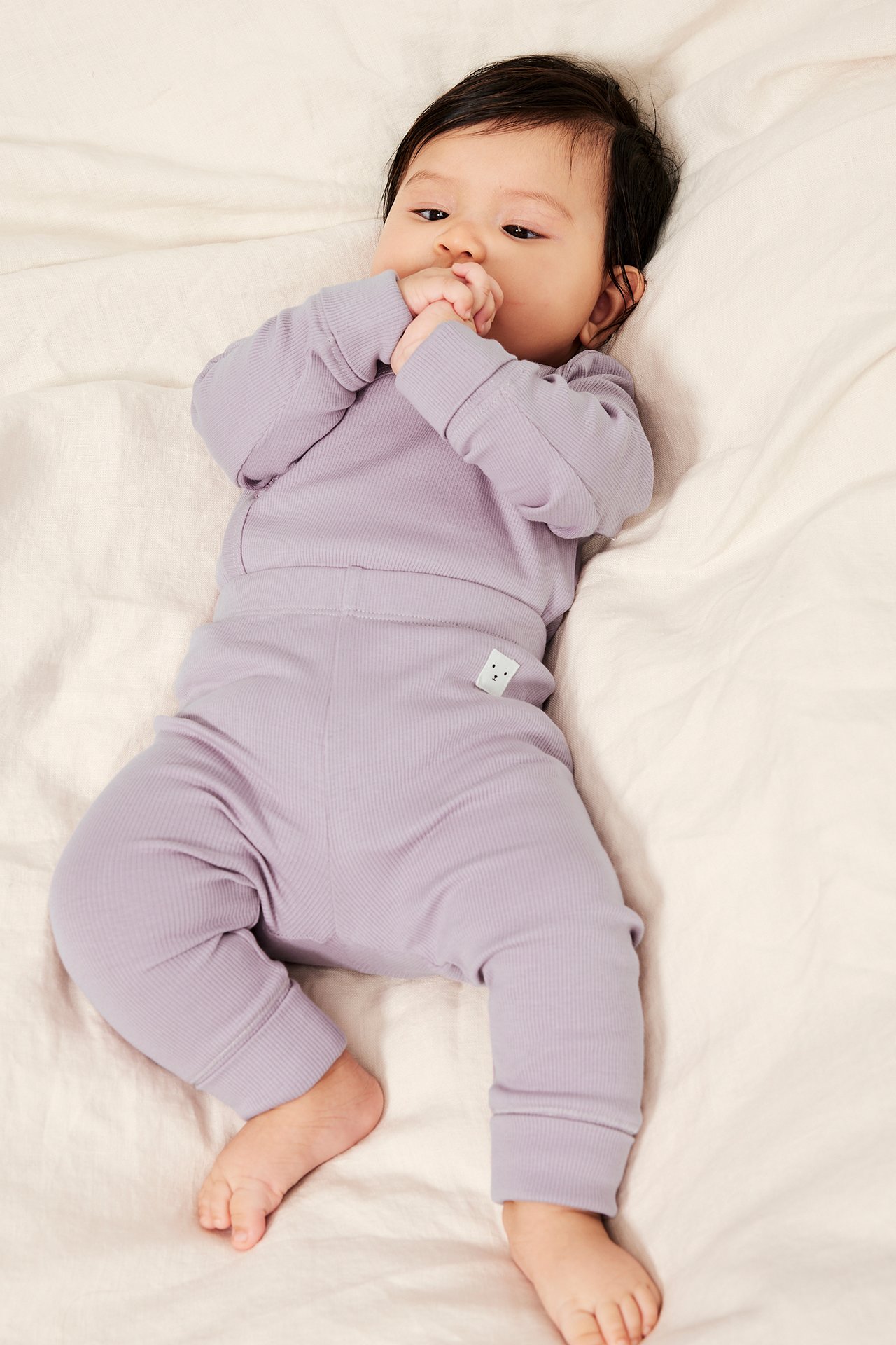 Ylhäältä: Vauva violetinvärisissä ribatuissa leggingseissä, joissa leveät resorit, ja vastaavassa pitkähihaisessa paidassa.