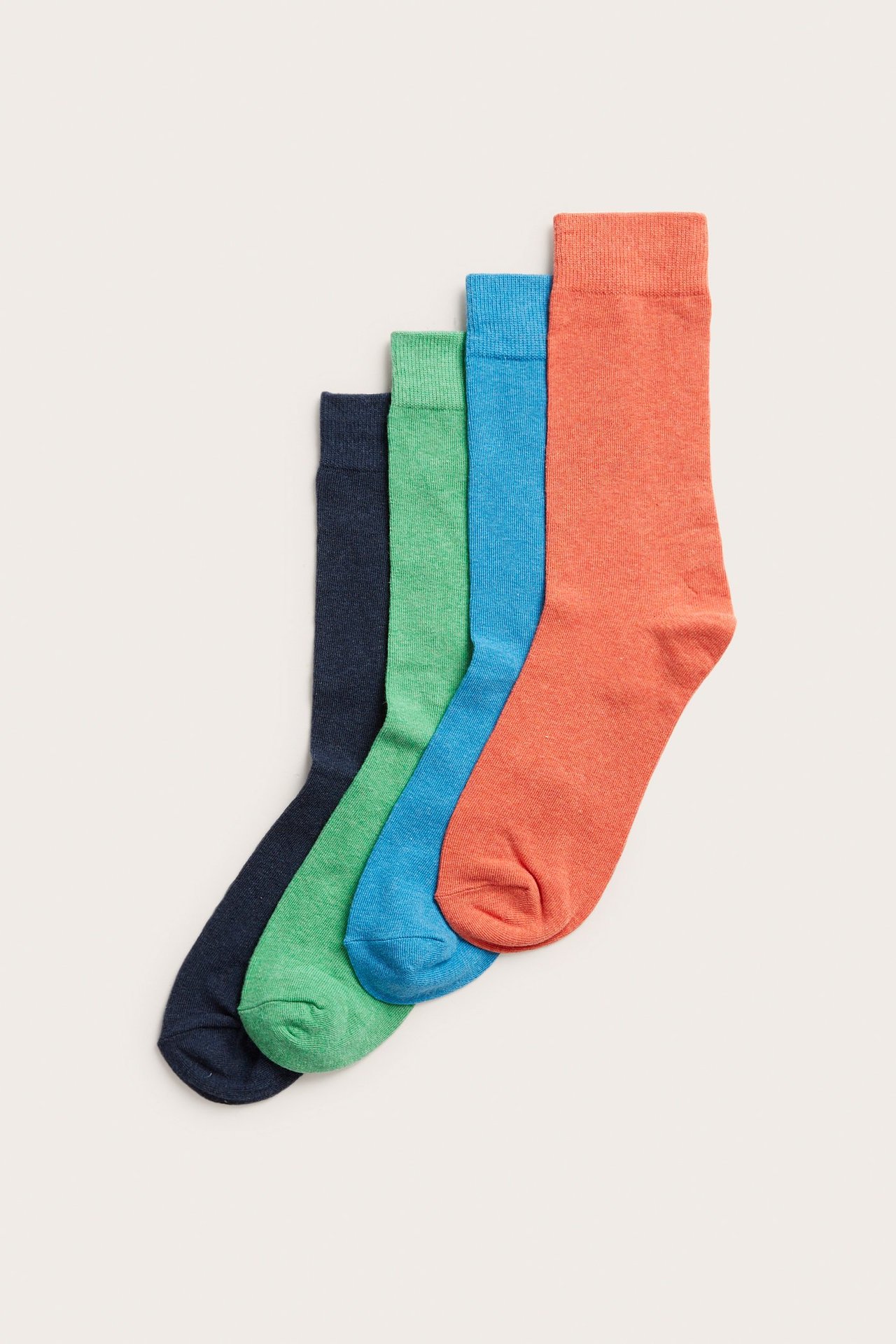 Översiktsbild av fyra melerade strumpor i bomullsblandning: orange, blå, grön och mörkblå.