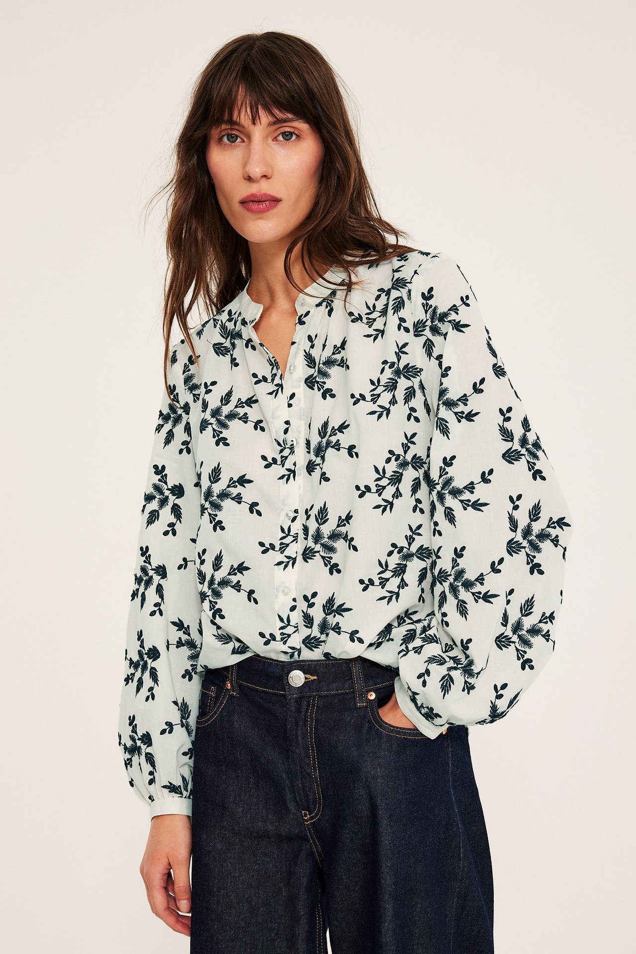 Offwhite bluse med broderte blomster, knapper, løs passform, lange ermer, over jeans.
