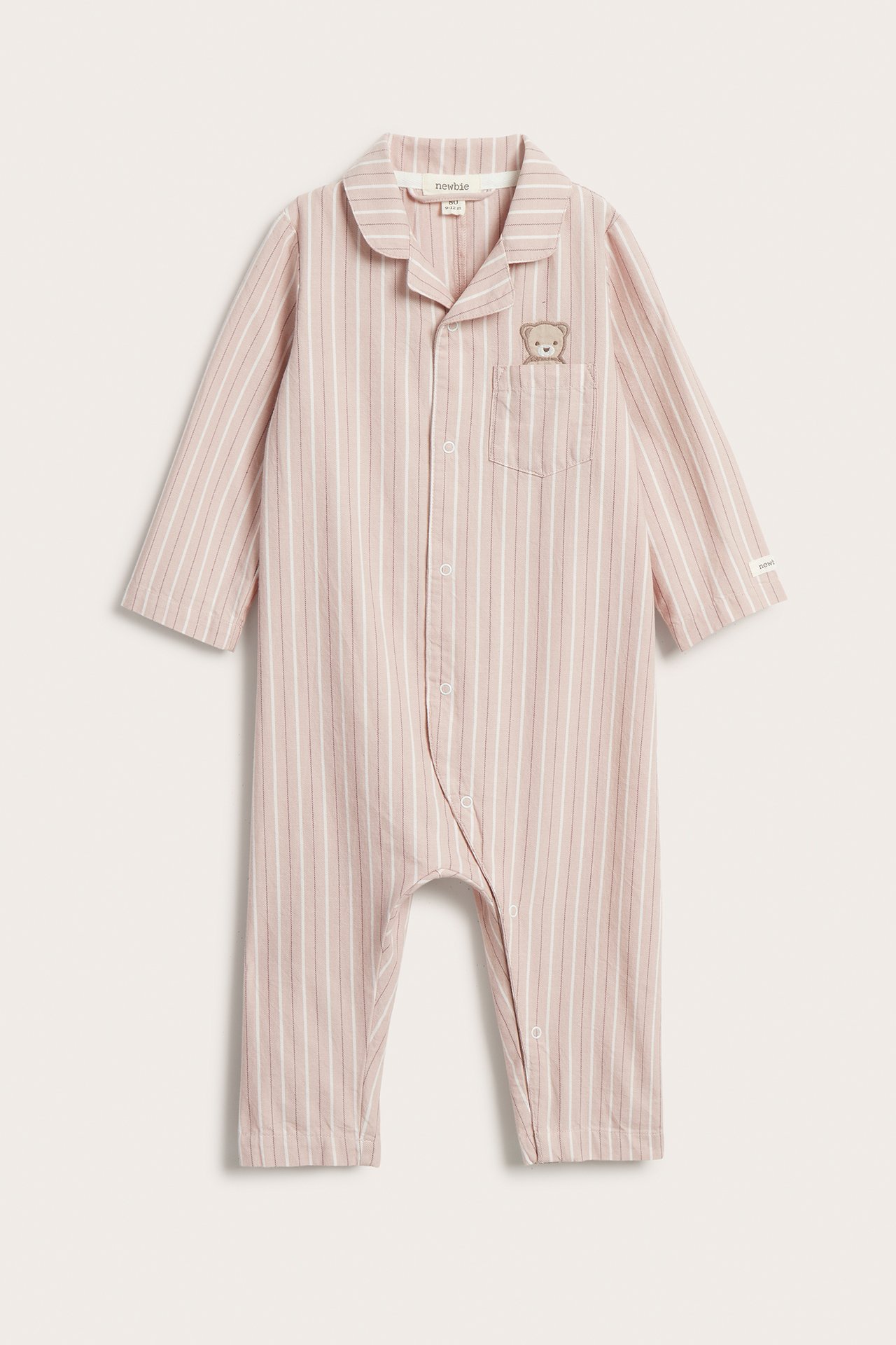 Front view: Vaaleanpunainen raidallinen vauvan pyjama, jossa rintataskussa brodeerattu nalle.