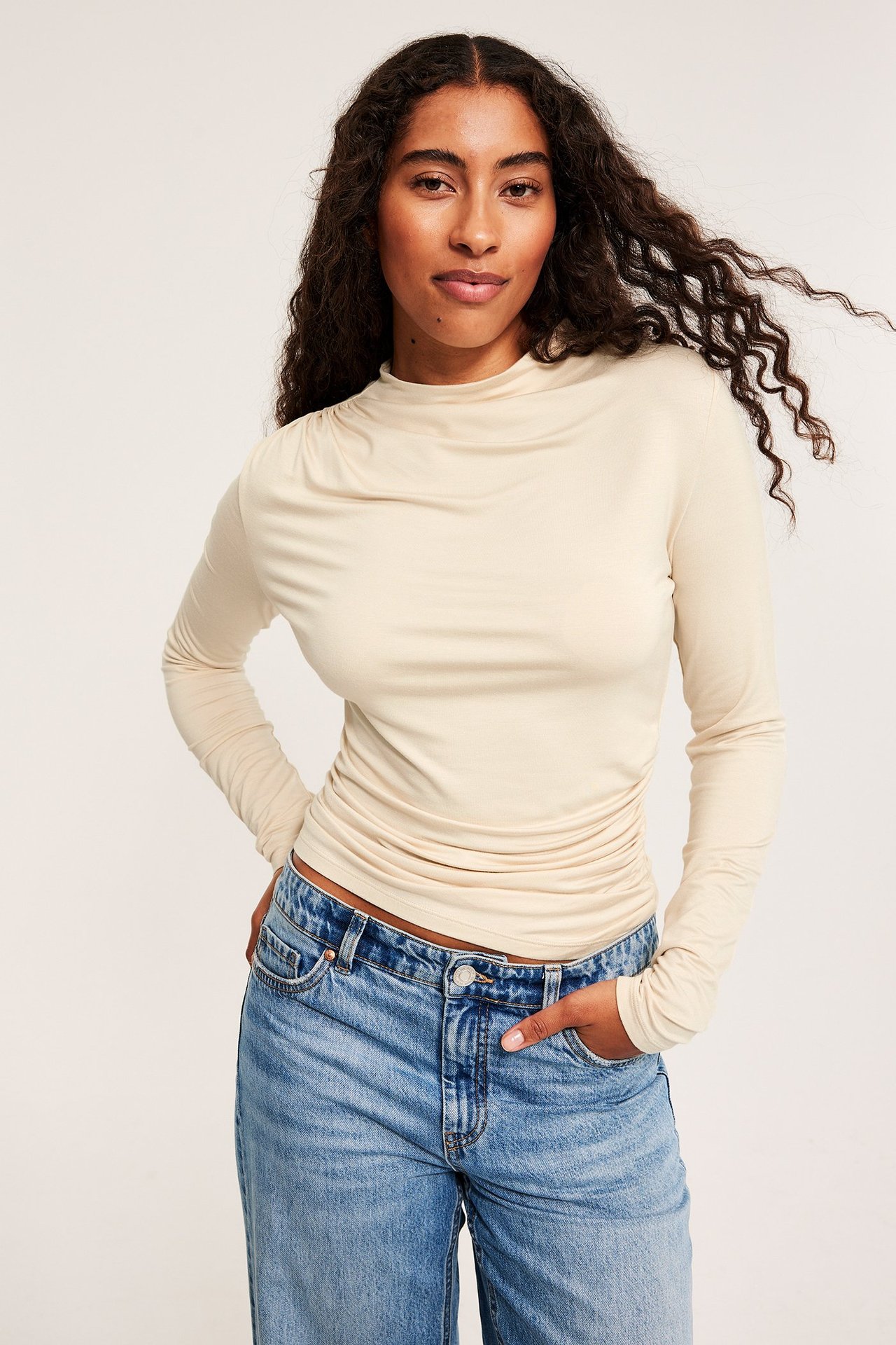 Langermet lys beige viskotopp med drapering, på kvinne.