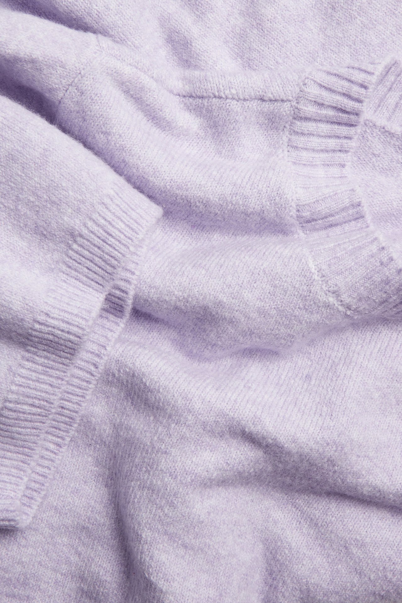 Lähikuva vaaleanliilasta meleeratusta neulotusta t-paidasta, jossa on pyöreä pääntie ja 3/4 resorihihat.