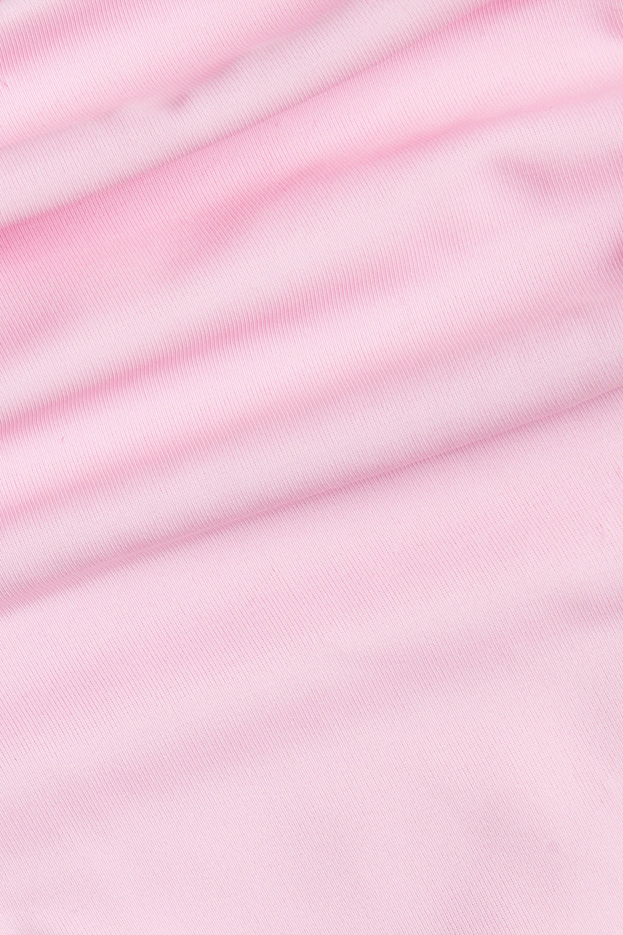 Närbild av det enfärgade rosa ribbade tyget till en brazilian bikinitanga.