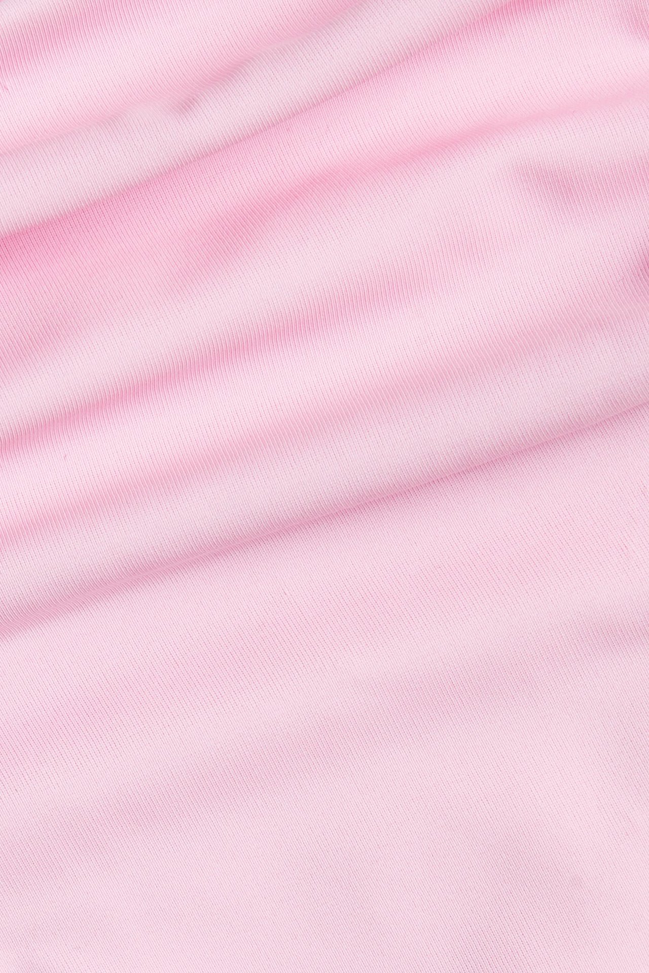 Närbild av det enfärgade rosa ribbade tyget till en brazilian bikinitanga.