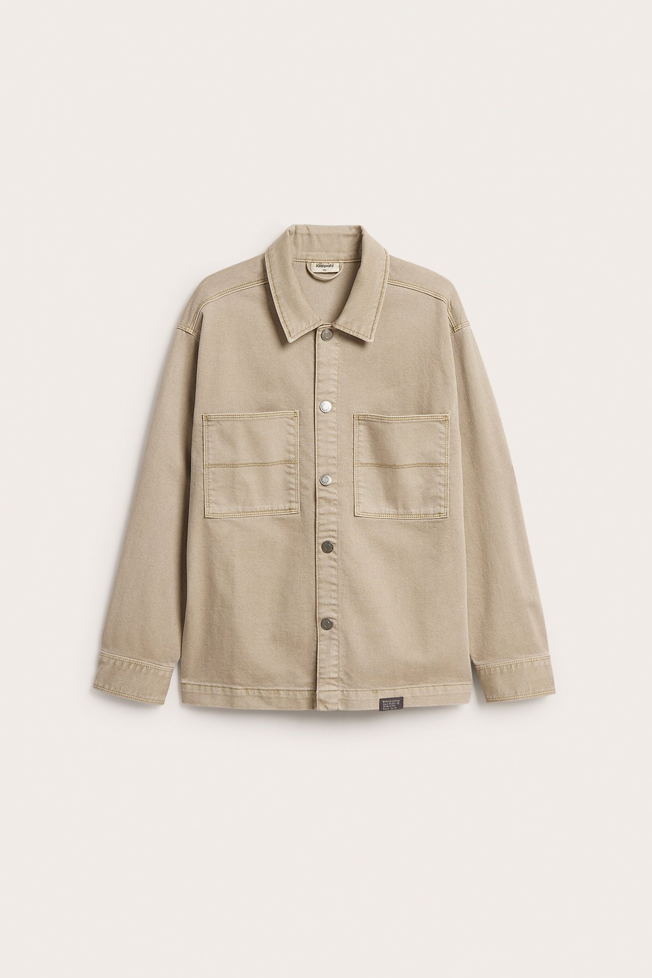 Forfra en beige overshirt i bomullstwill med trykknapper og to brystlommer.