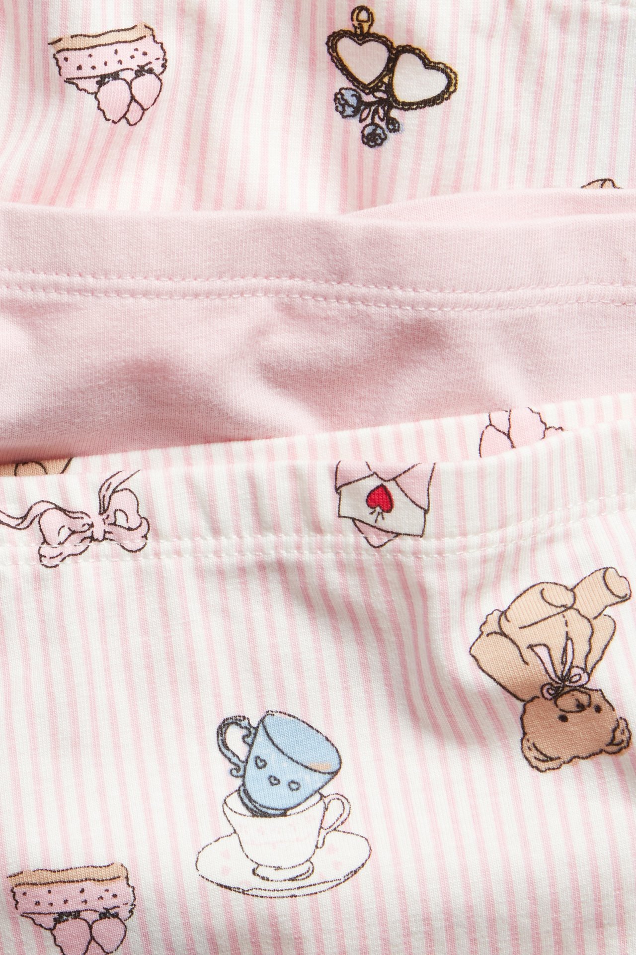 Lähikuva lasten vaaleanpunaisista bokserialushousuista: yhdet yksiväriset, kahdet raidalliset ja söpöillä kuvioilla.