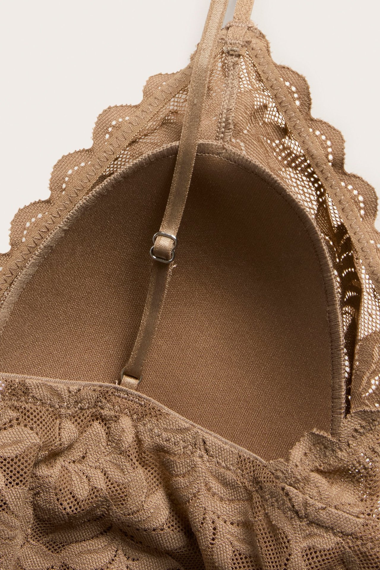 Zbliżenie brązowego koronkowego biustonosza top z usztywnieniem i regulowanym ramiączkiem.