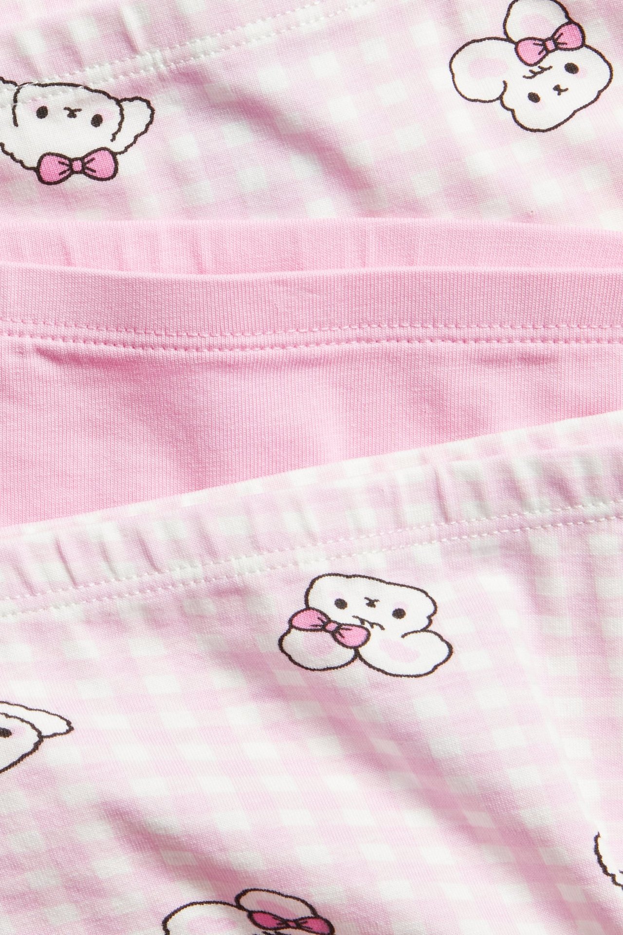 Lähikuva lasten 3-pack boksereista: kaksi pinkkiä kuviollisena, yksi yksivärinen pinkki puuvillasekoite.