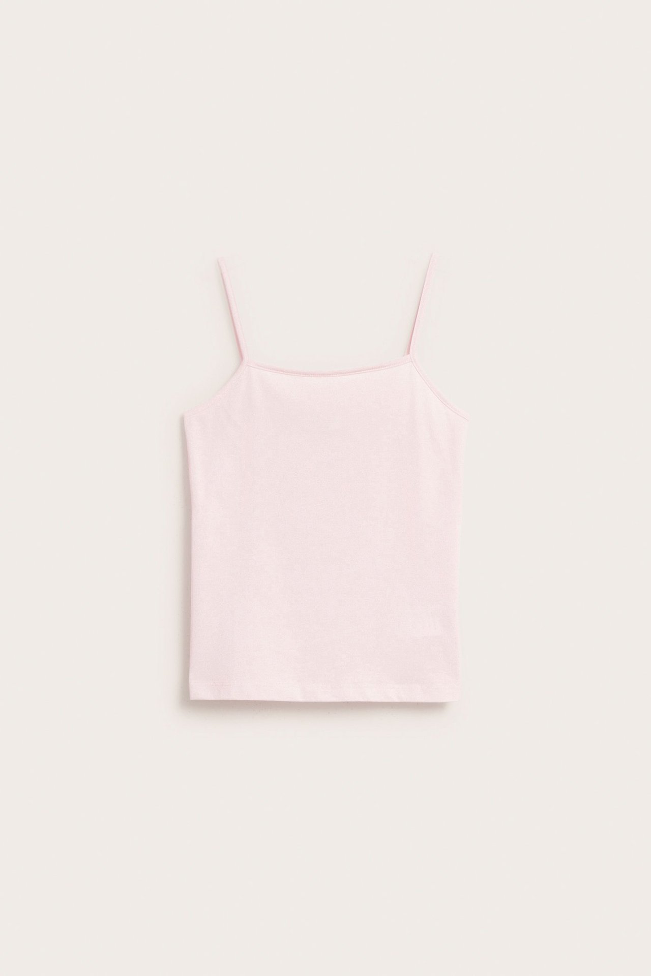 Widok z przodu: jasnoróżowy dziecięcy podkoszulek z cienkimi ramiączkami z mieszanki bawełny.