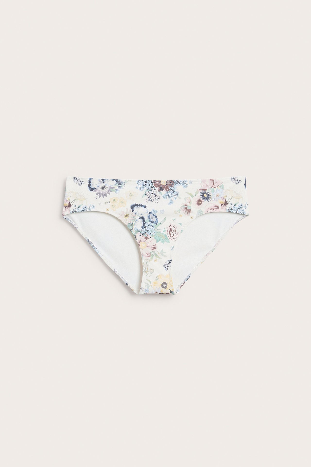 Framifrån, offwhite bikinitrosa i briefmodell med färgglatt blommigt mönster.