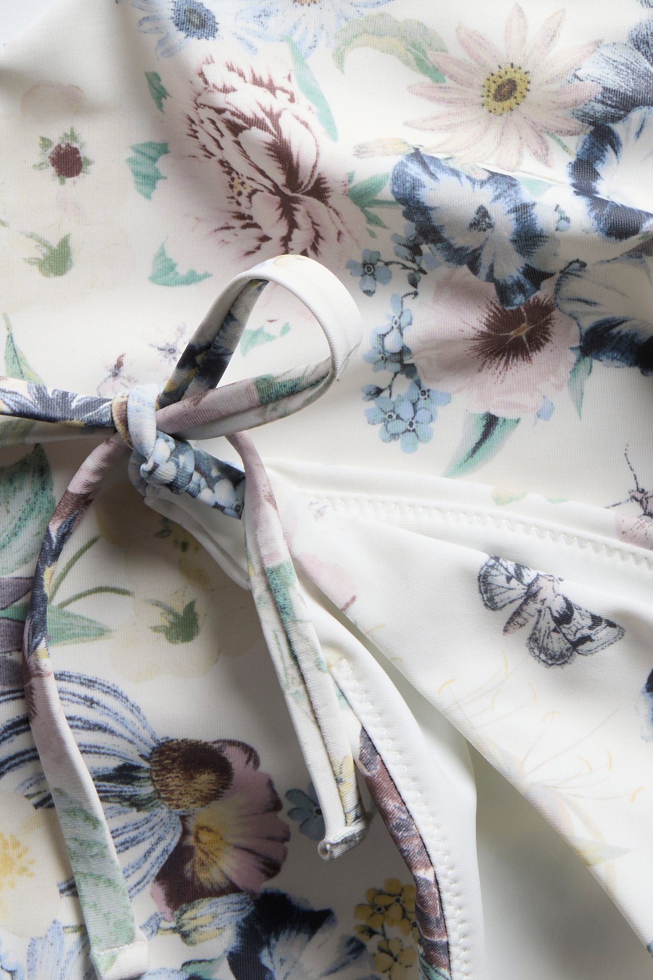 Närbild av en offwhite mönstrad bikiniunderdel med knytband.