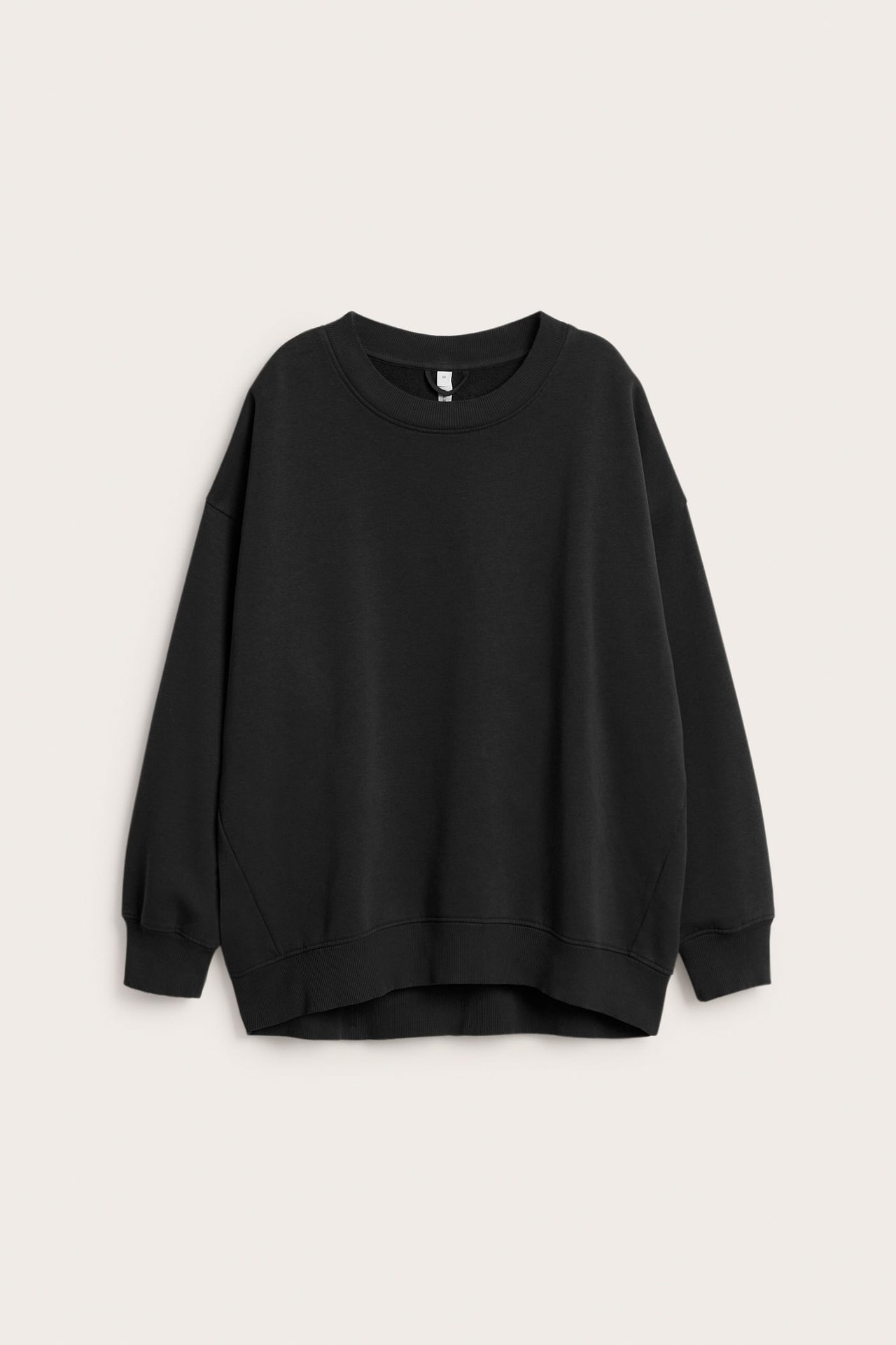 Frontutsikt: en ensfarget svart oversized sweatshirt med lange ermer og ribbestrikket nederkant.