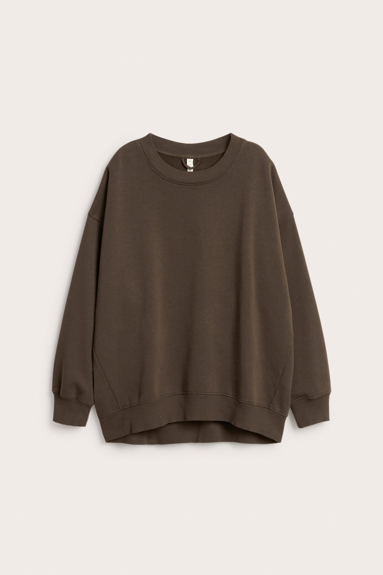 Frontbilde av en oversized mørkebrun sweatshirt med rund hals, lange ermer og ribbestrikkede mansjetter.