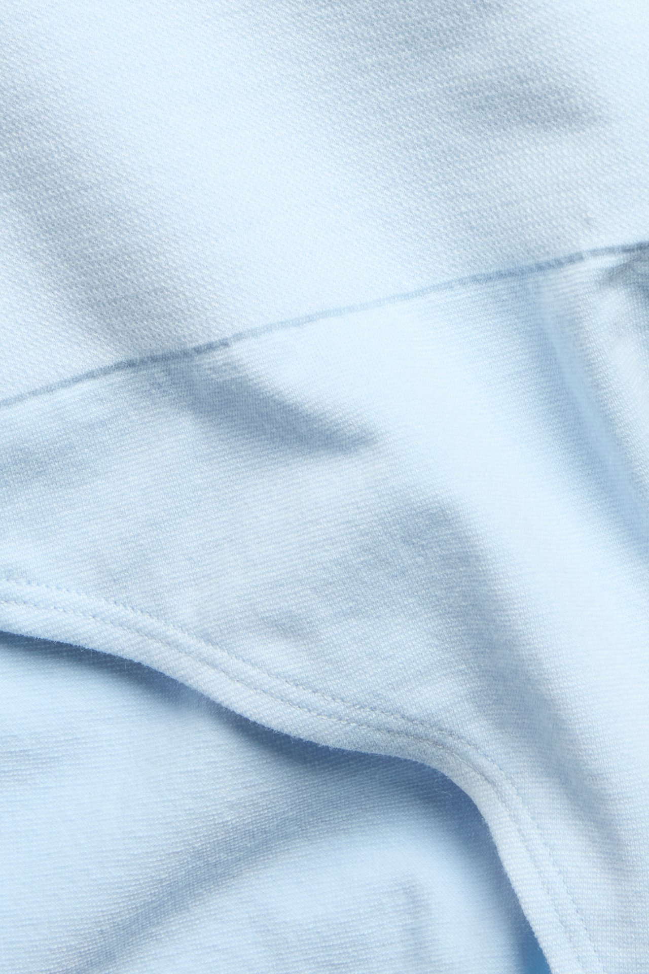 Zbliżenie na jasnoniebieskie, bezszwowe figi z wysokim stanem i prążkowanym pasem.